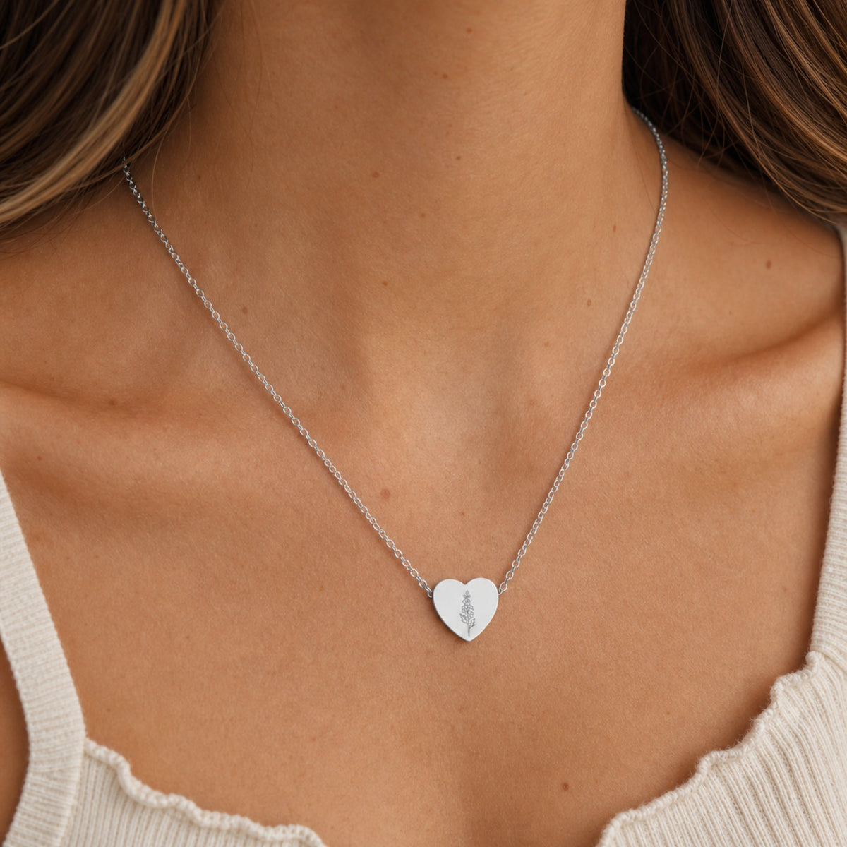 July birth flower necklace with larkspur engraving in polished 316L stainless steel, worn on model
