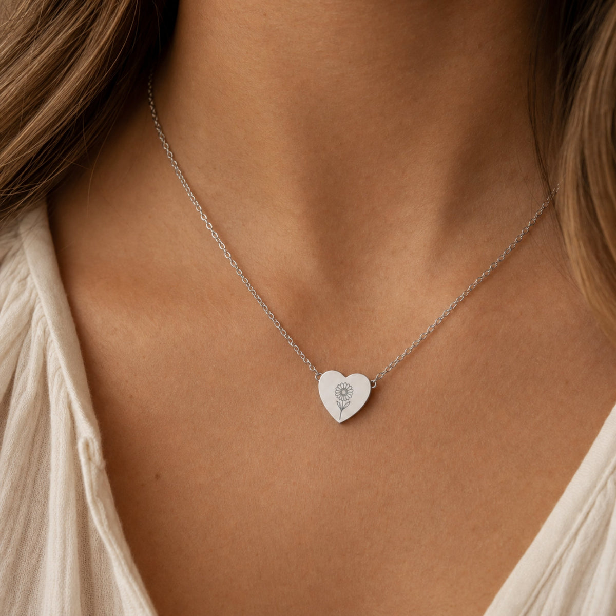 April birth flower necklace with daisy engraving in polished 316L stainless steel, worn on model