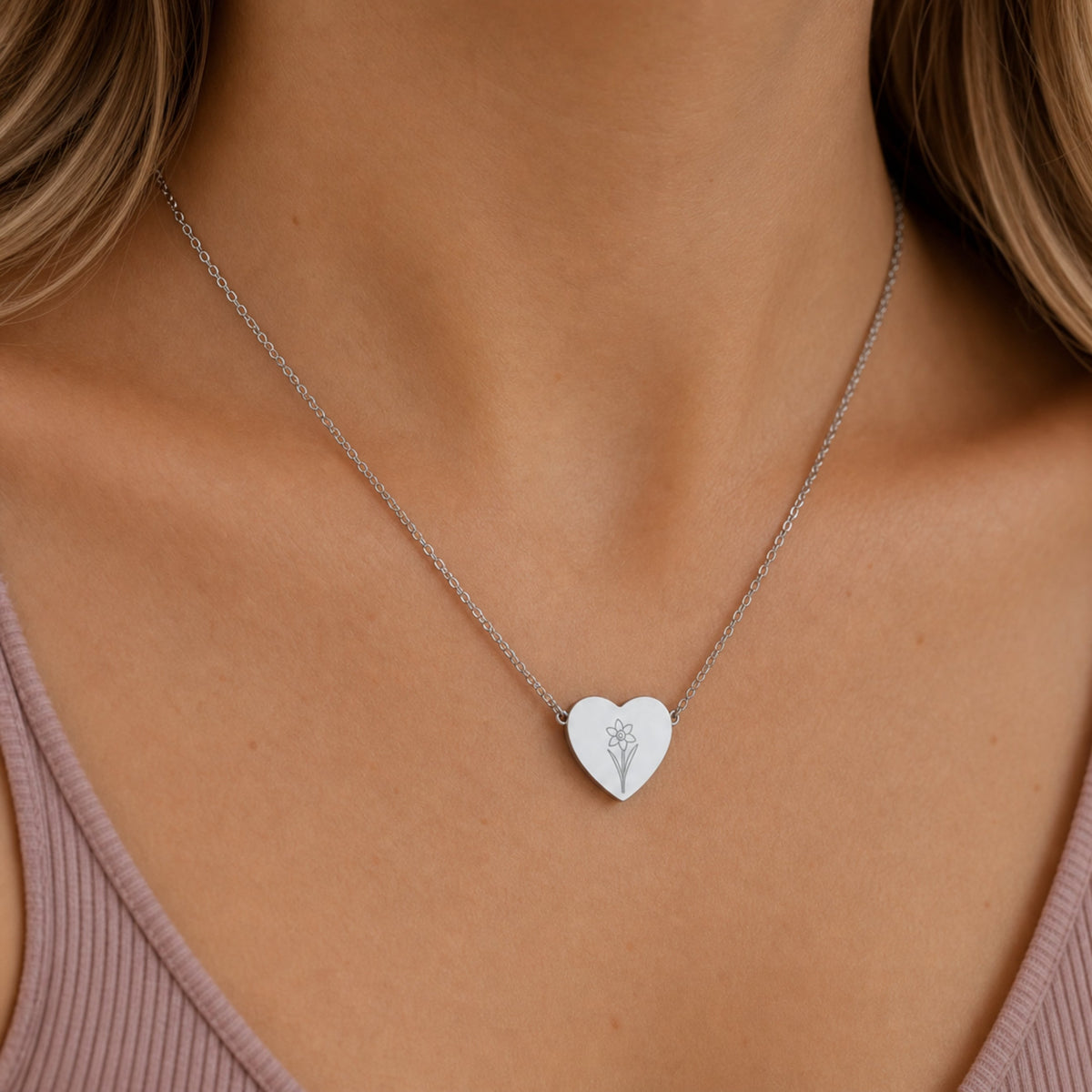 December birth flower necklace with narcissus engraving in polished 316L stainless steel, worn on model