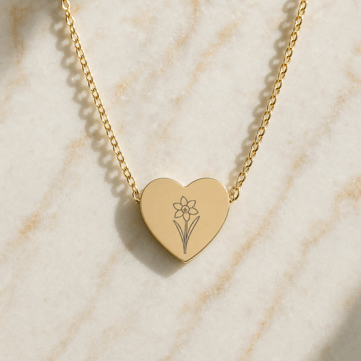 December birth flower necklace with narcissus engraving on linen flatlay with full chain