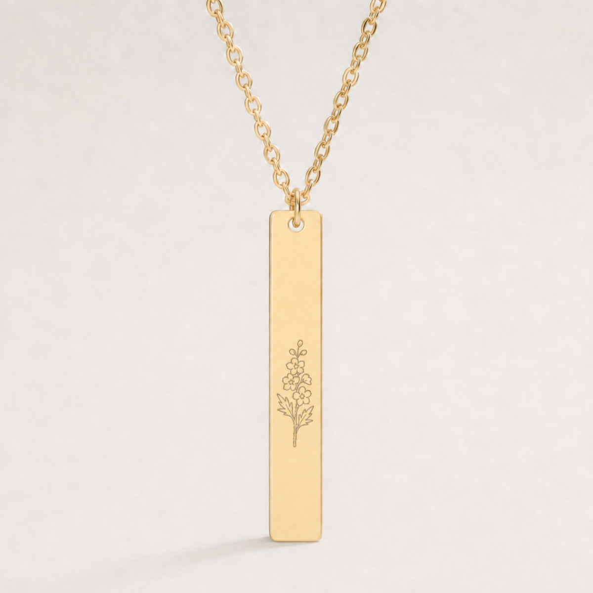 July birth flower necklace — Larkspur engraved on 1.26" × 0.20" vertical bar pendant, premium close-up macro hero on 18K Gold PVD