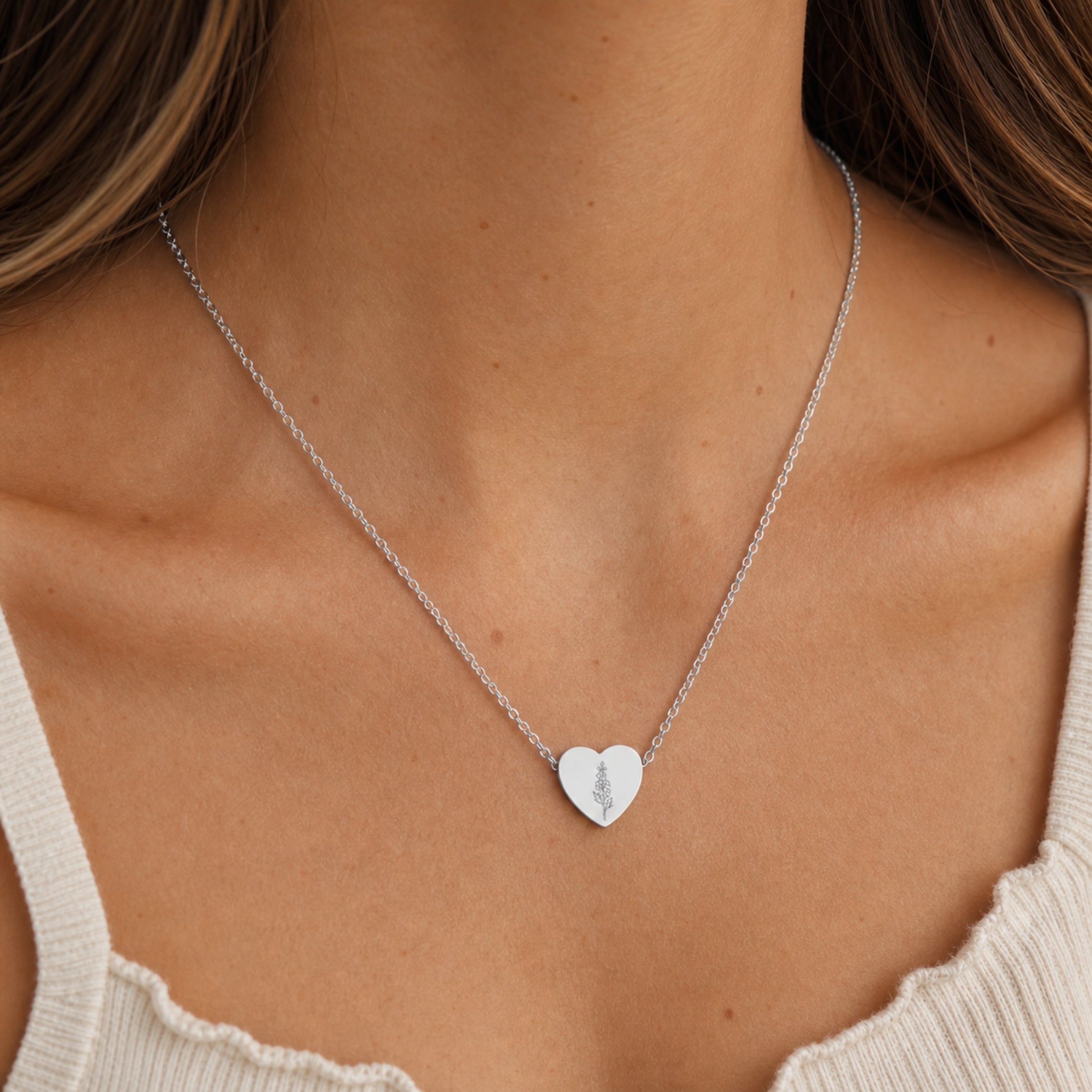 July birth flower necklace with larkspur engraving in polished 316L stainless steel, worn on model