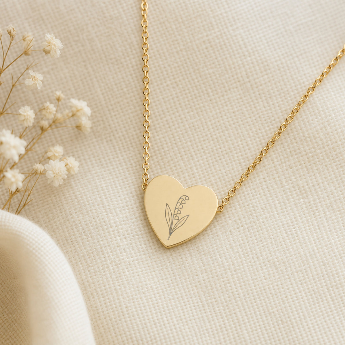 May birth flower necklace with lily of the valley engraving on linen flatlay with full chain