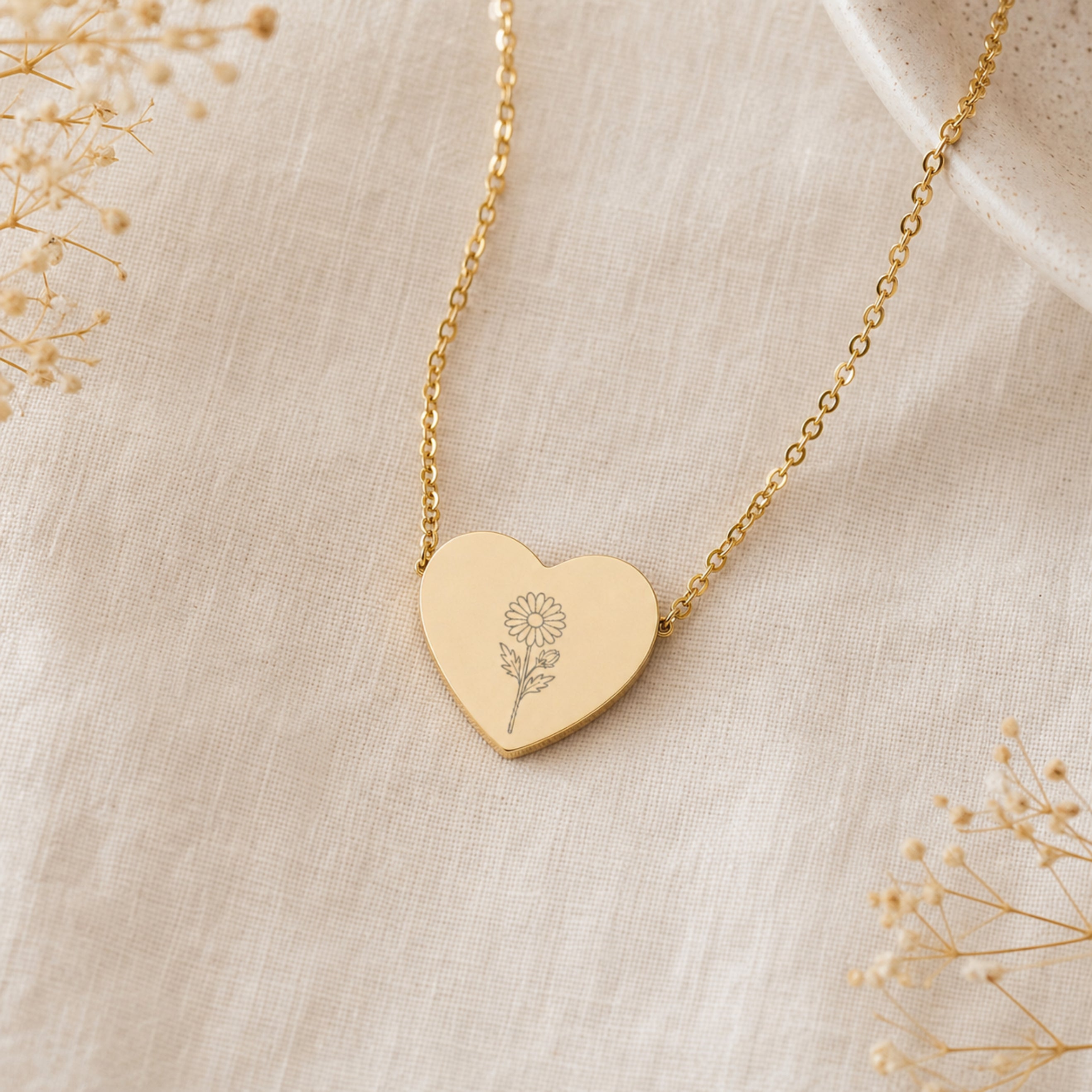 September birth flower necklace with aster engraving on linen flatlay with full chain
