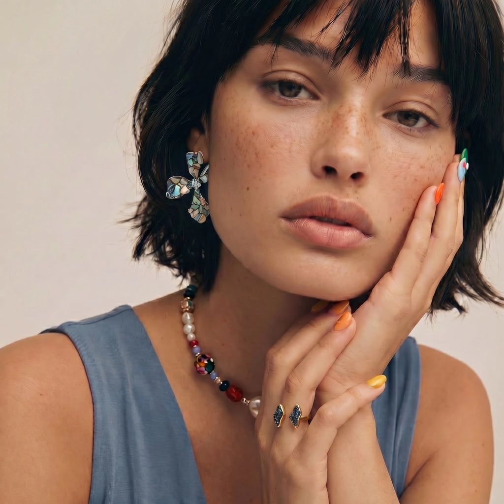 Woman wearing Celestial Shell Cross Studs with iridescent abalone mosaic petals