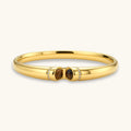 Polished gold bangle with two oval tiger's eye cabochons flanked by pavé crystal accents at center clasp.