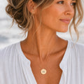 Aquarius zodiac coin necklace worn on model in 18K gold — engraved Aquarius Water-bearer pendant resting on chest, layered everyday necklace, personalized birthday gift for Aquarius, January February zodiac