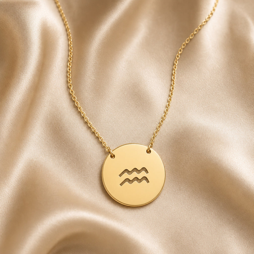 Aquarius Coin Gold zodiac necklace flatlay — 18K gold pendant engraved with Aquarius Water Bearer star sign on cream silk, premium personalized astrology necklace gift for January February birthday, Aquarius woman, mother, daughter