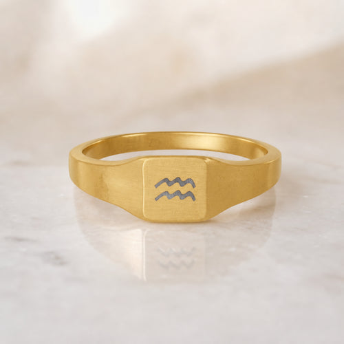 Aquarius zodiac square signet ring — hero macro of laser-engraved Water-bearer waves on 18K gold square face, premium personalized astrology ring gift
