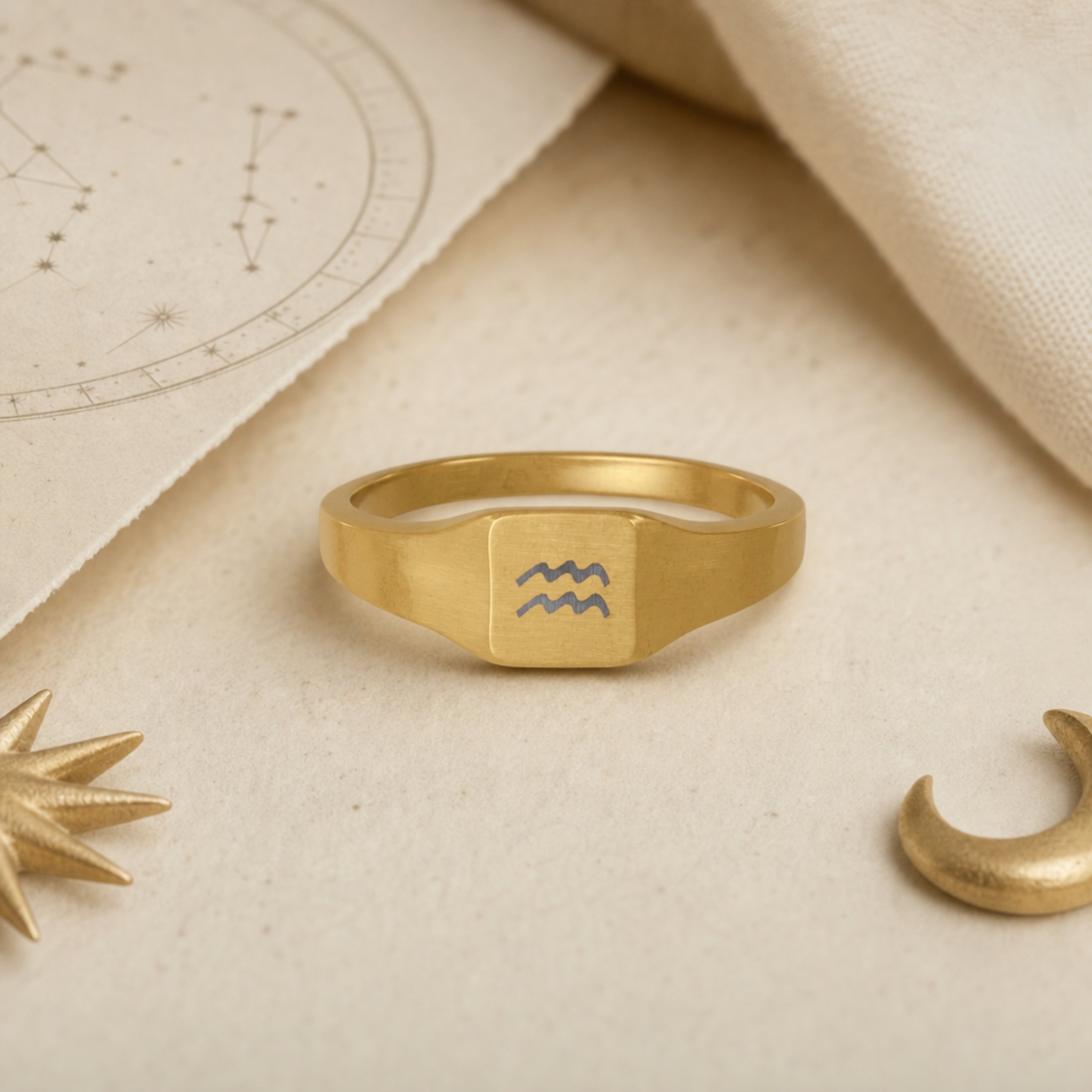 Aquarius zodiac square signet ring celestial flatlay — zodiac chart and brass star with engraved Aquarius signet, astrology gift styling