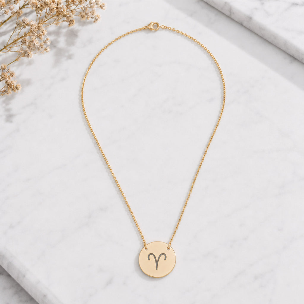 Aries zodiac coin necklace marble flatlay — 18K gold pendant engraved with Aries Ram star sign on white marble with dried floral, premium personalized astrology necklace gift for April birthday, Ariesian present