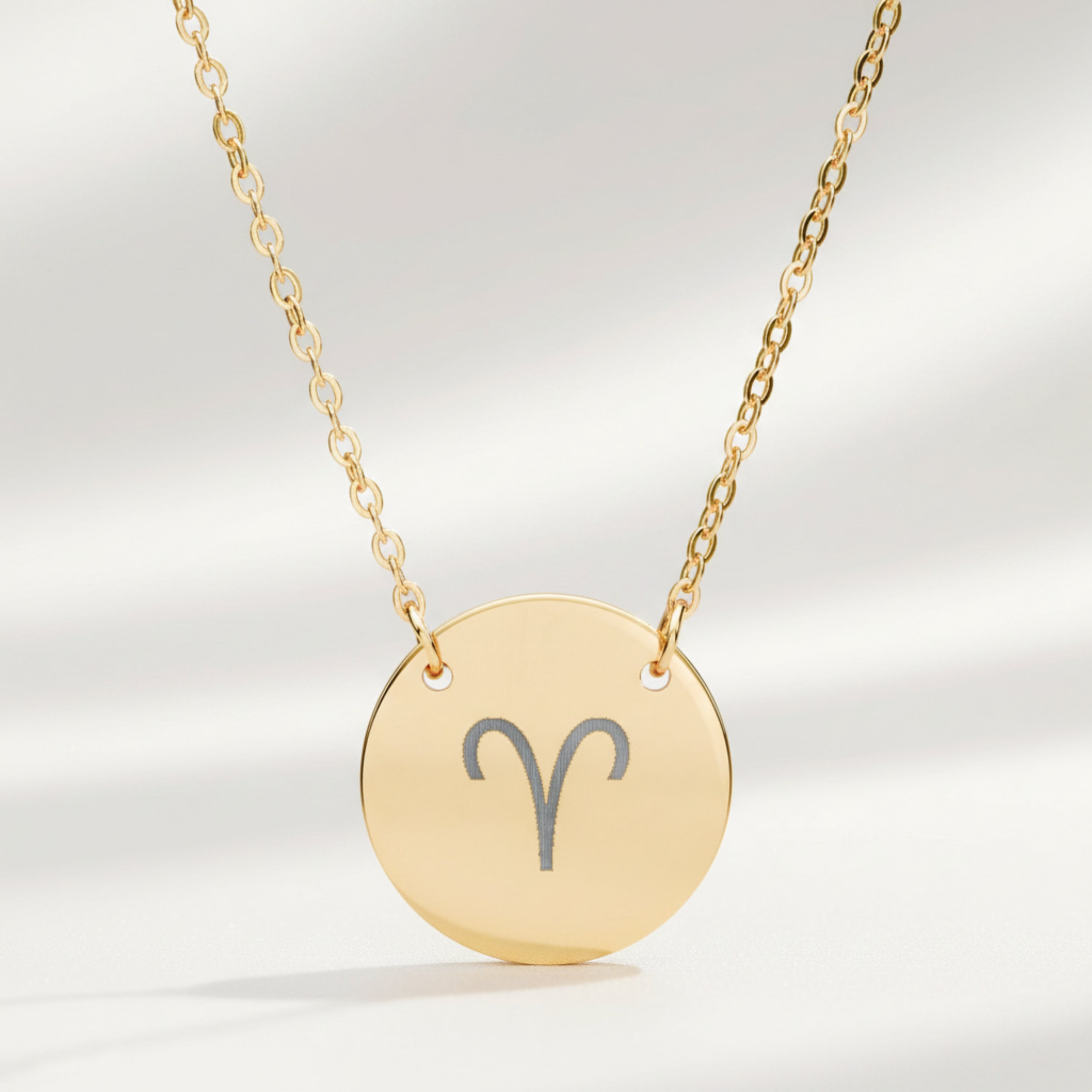 Aries zodiac coin necklace close-up — laser-engraved Aries star sign on 18K gold pendant