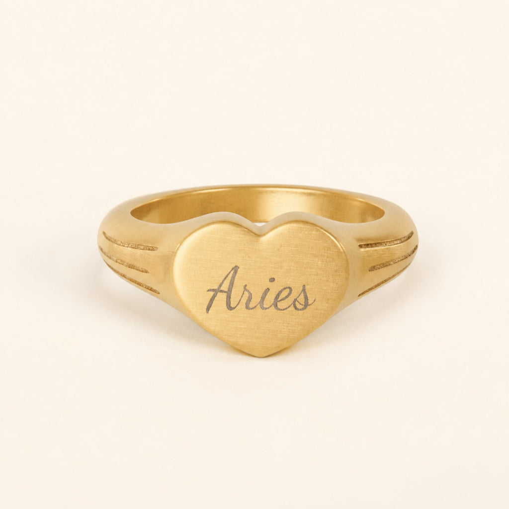 Aries zodiac heart signet ring studio front — clean cream backdrop product shot, 18K gold matte PVD