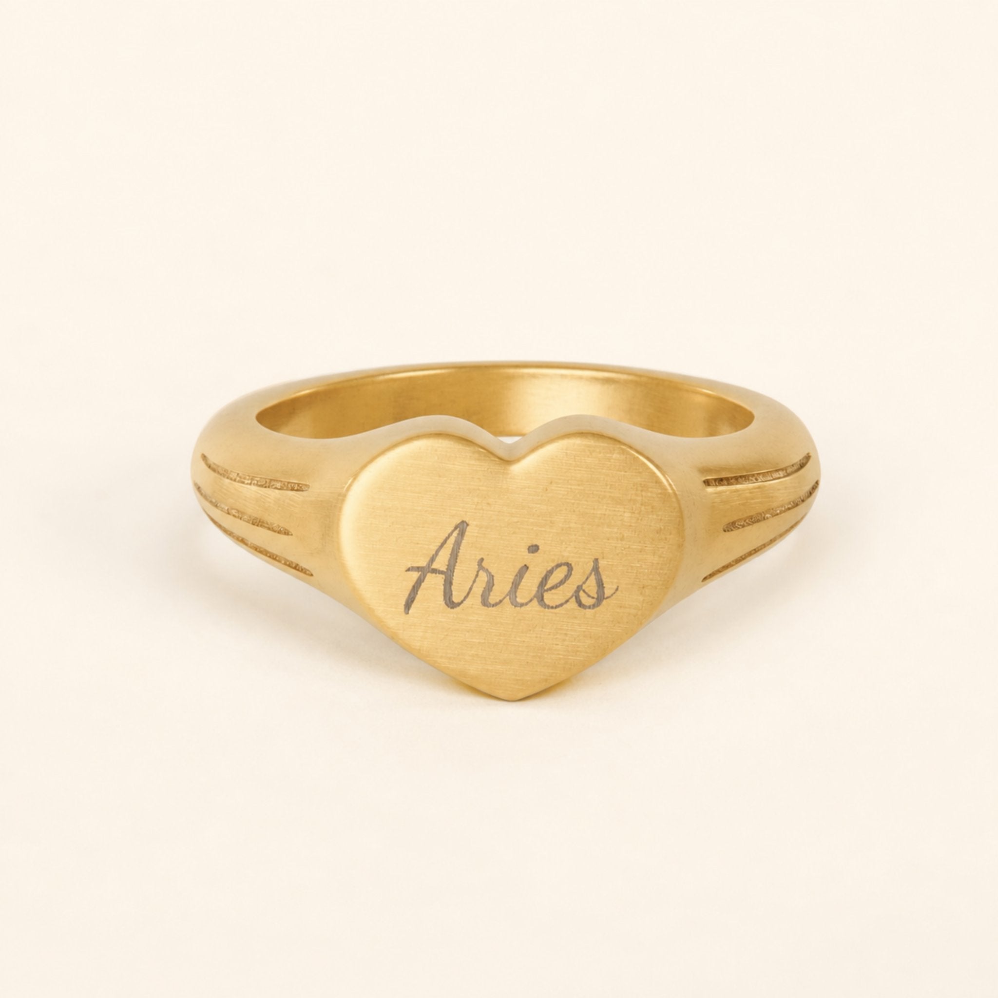 Aries zodiac heart signet ring studio front — clean cream backdrop product shot, 18K gold matte PVD