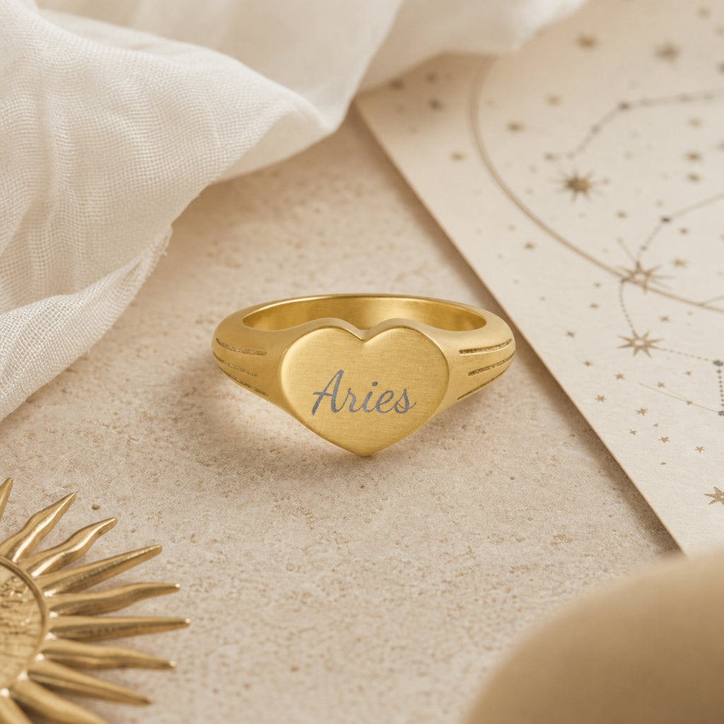 Aries zodiac heart signet ring celestial flatlay — zodiac chart and brass star with engraved Aries heart signet, astrology gift styling