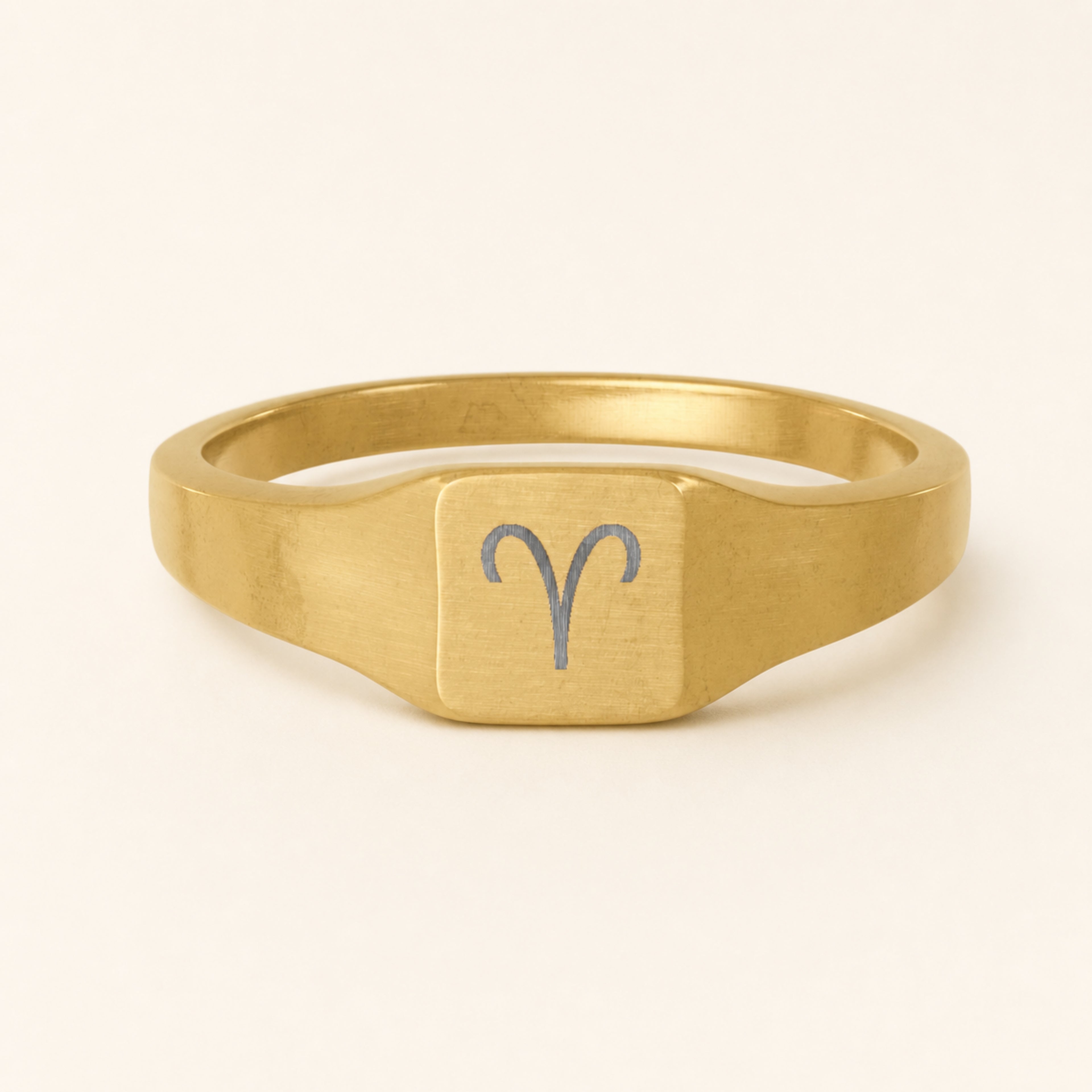 Aries zodiac square signet ring studio front — clean cream backdrop product shot, 18K gold matte PVD