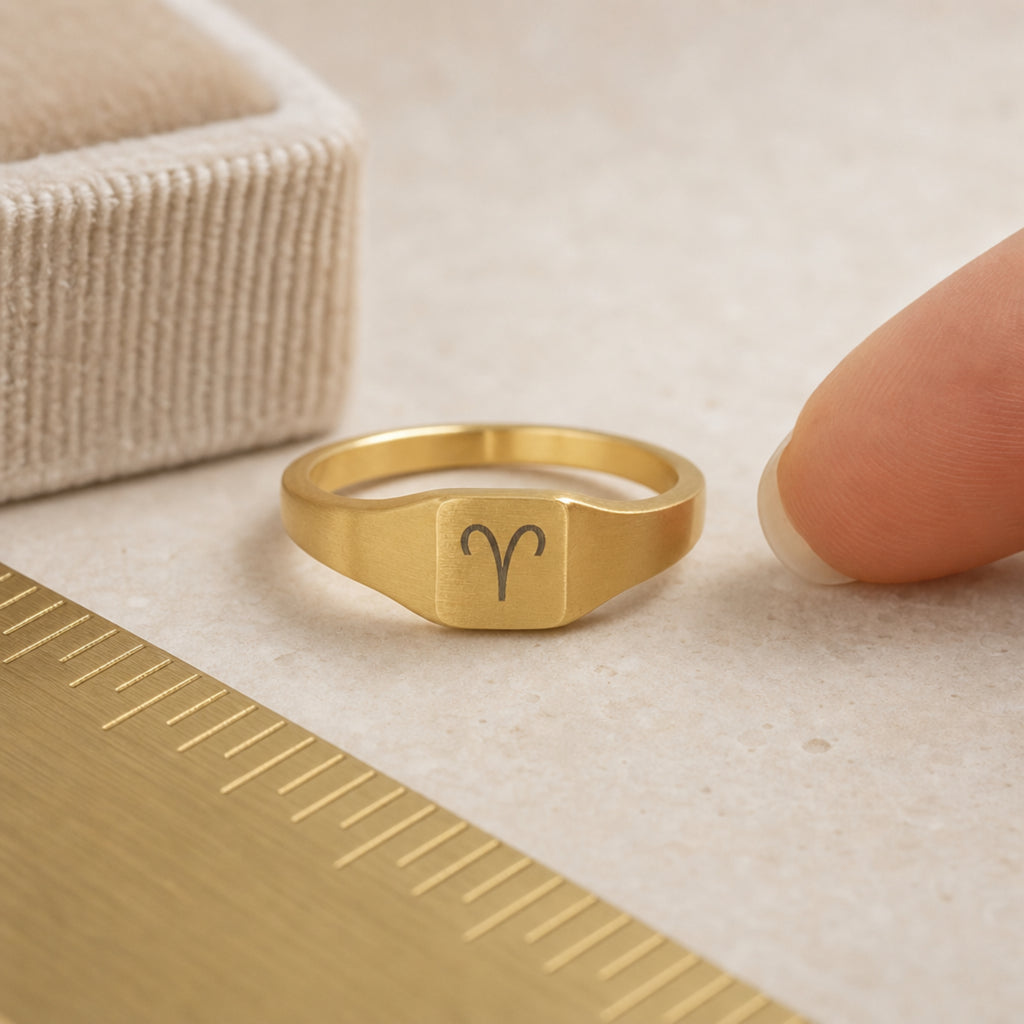 Aries zodiac square signet ring scale-in-hand — fingers holding ring next to gift box and ruler, dainty 20mm signet sizing