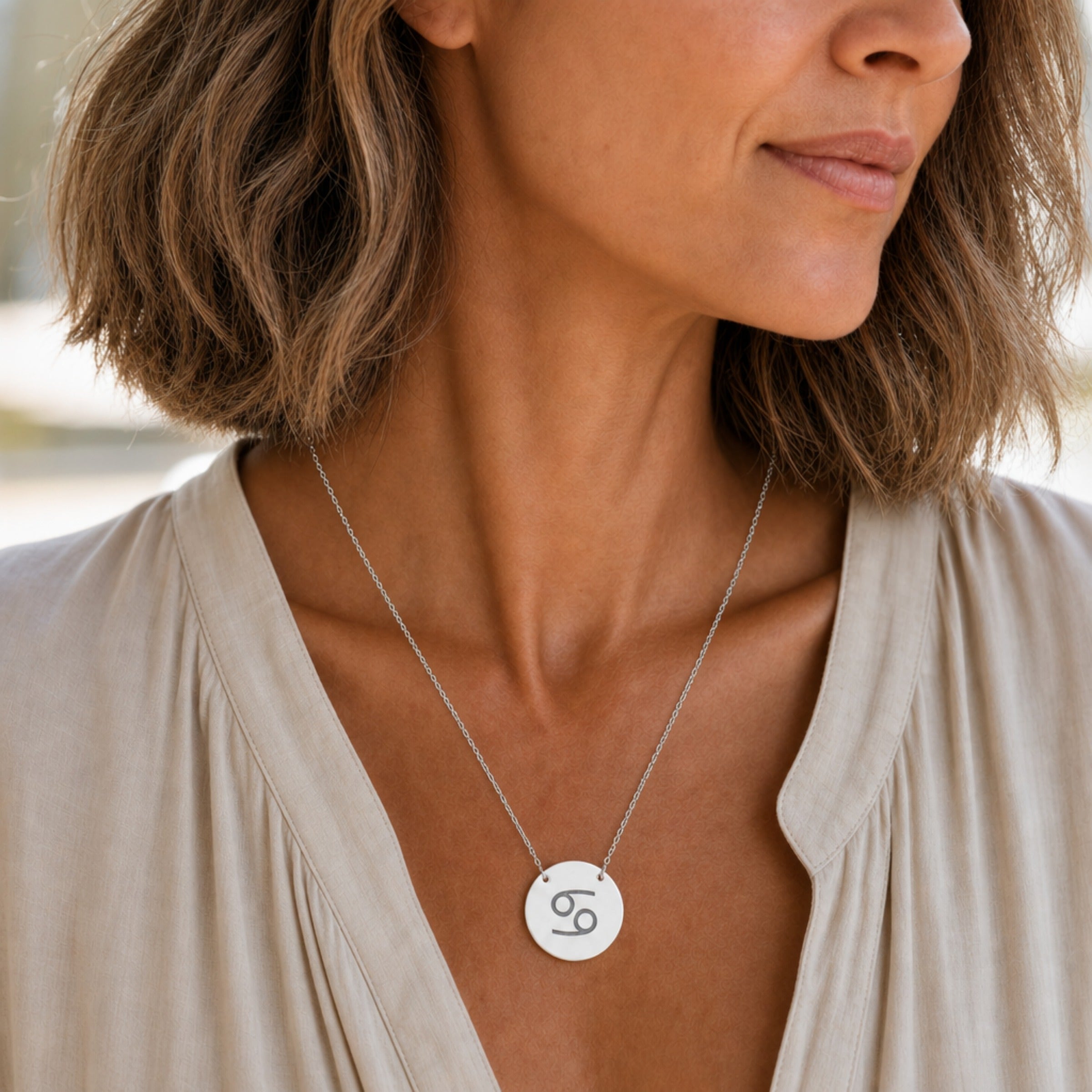 Cancer zodiac coin necklace in stainless steel worn on model — hypoallergenic Cancer Crab pendant, polished steel disc necklace, everyday personalized astrology gift