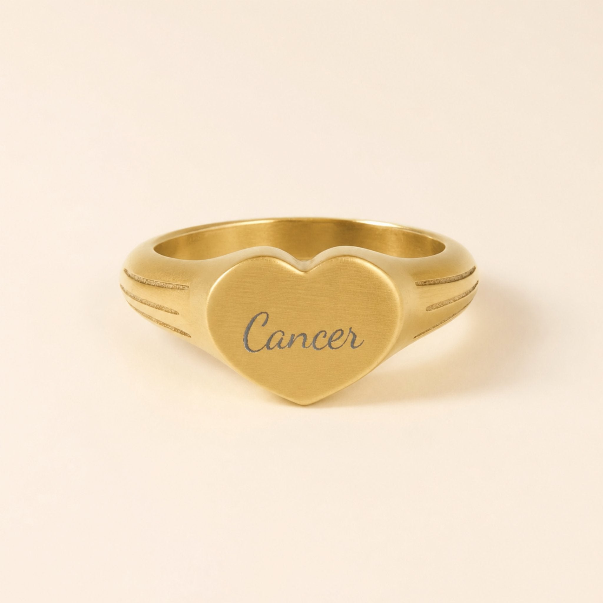 Cancer zodiac heart signet ring studio front — clean cream backdrop product shot, 18K gold matte PVD