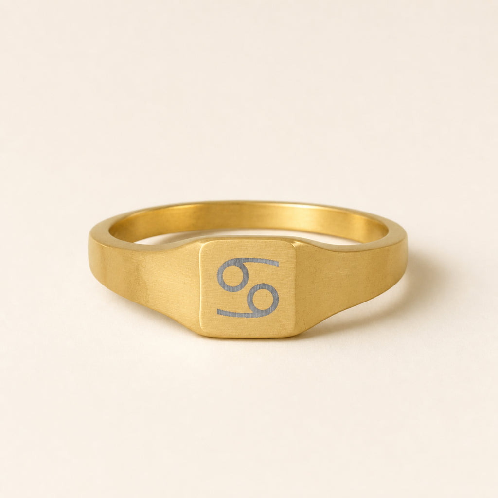Cancer zodiac square signet ring studio front — clean cream backdrop product shot, 18K gold matte PVD