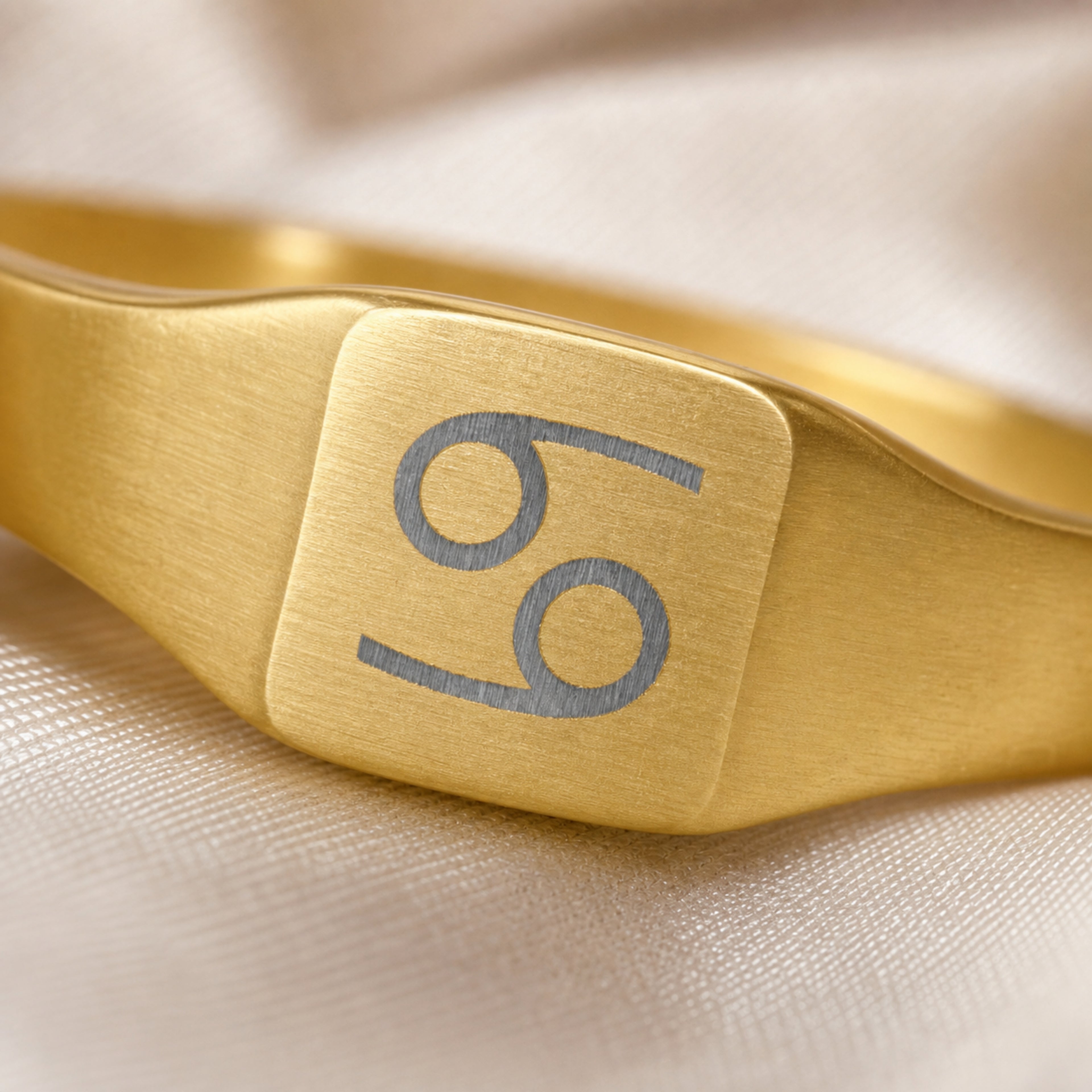 Cancer zodiac square signet ring engraving close-up — laser-etched Crab detail, brushed grey on matte gold
