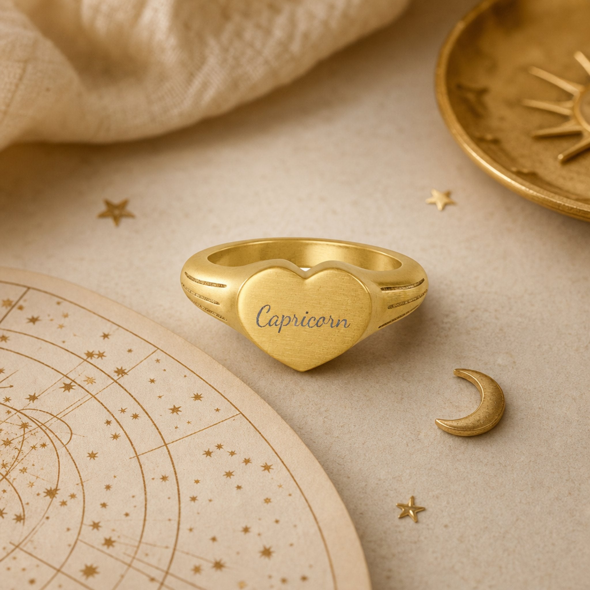 Capricorn zodiac heart signet ring celestial flatlay — zodiac chart and brass star with engraved Capricorn heart signet, astrology gift styling