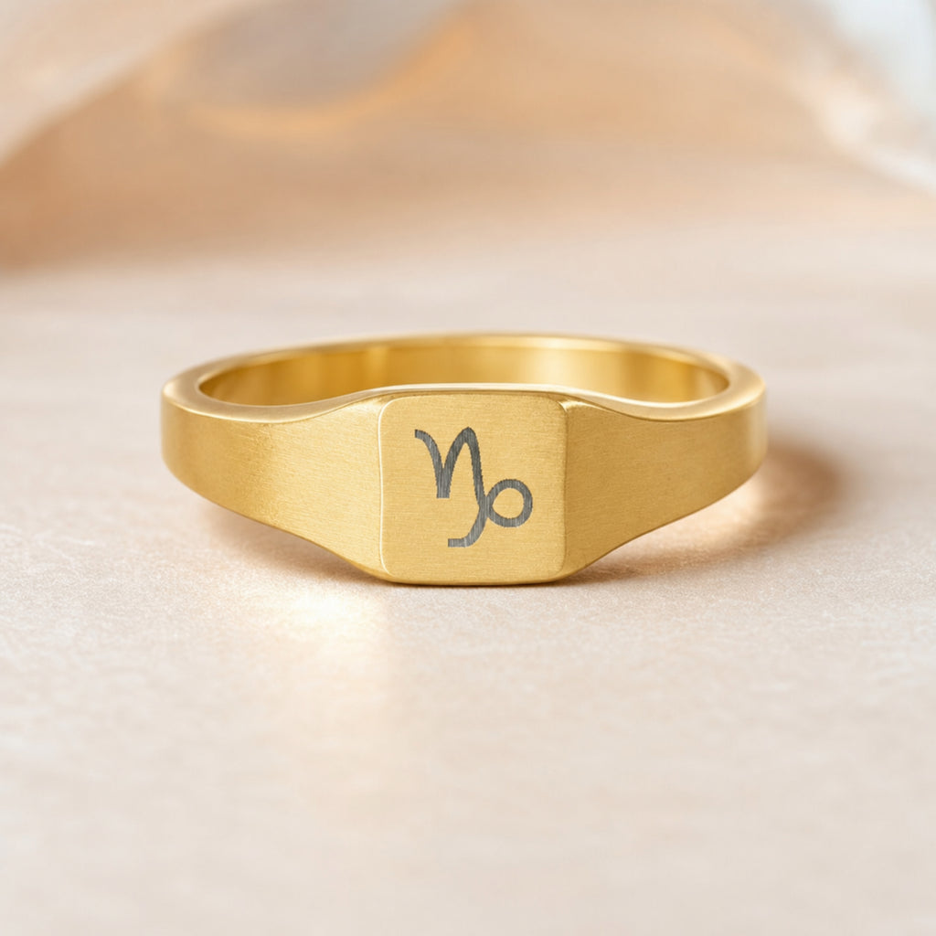 Capricorn zodiac square signet ring — hero macro of laser-engraved Goat on 18K gold square face, premium personalized astrology ring gift