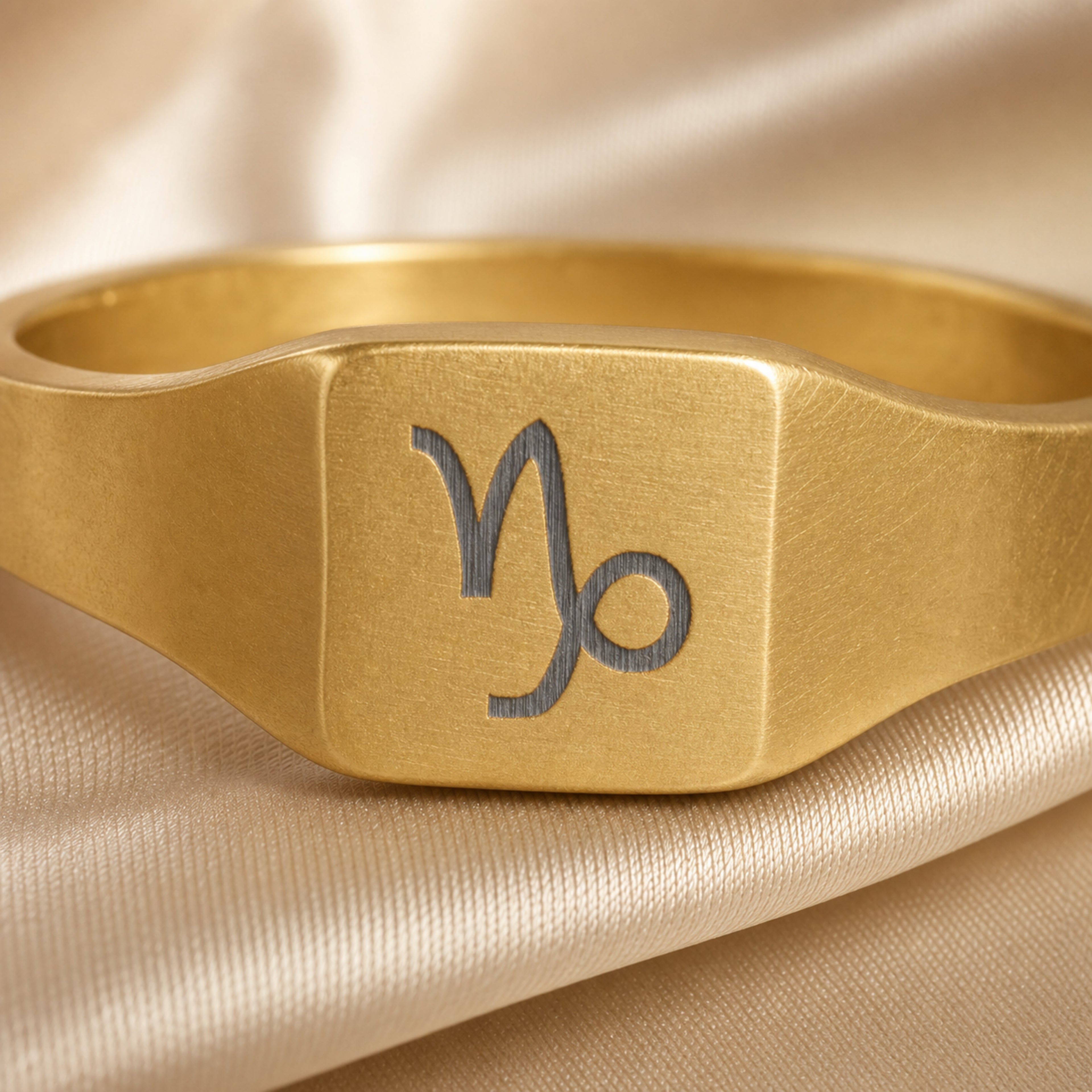 Capricorn zodiac square signet ring engraving close-up — laser-etched Goat detail, brushed grey on matte gold