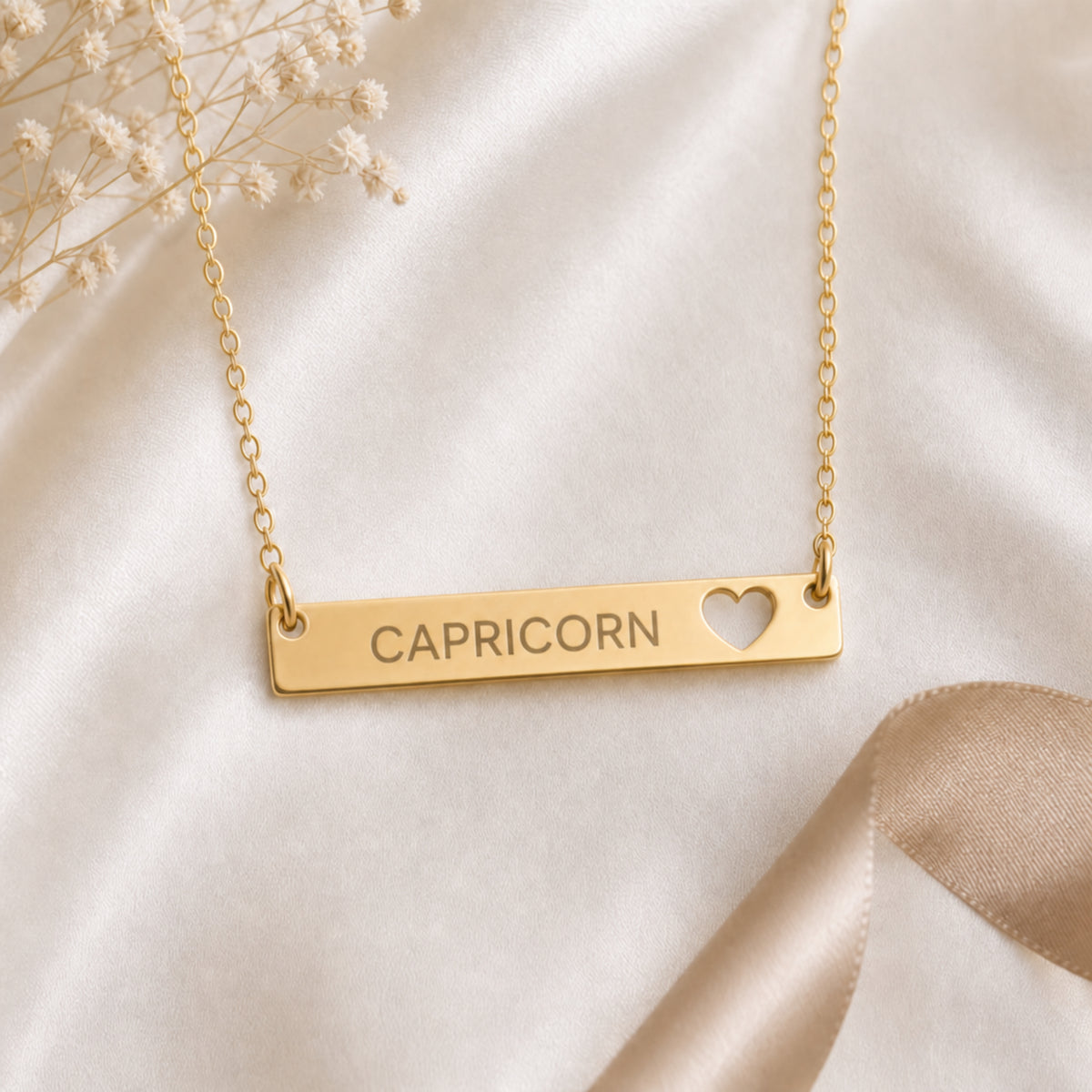 Capricorn zodiac necklace — cutout heart bar pendant flatlay with dried botanicals on cream linen
