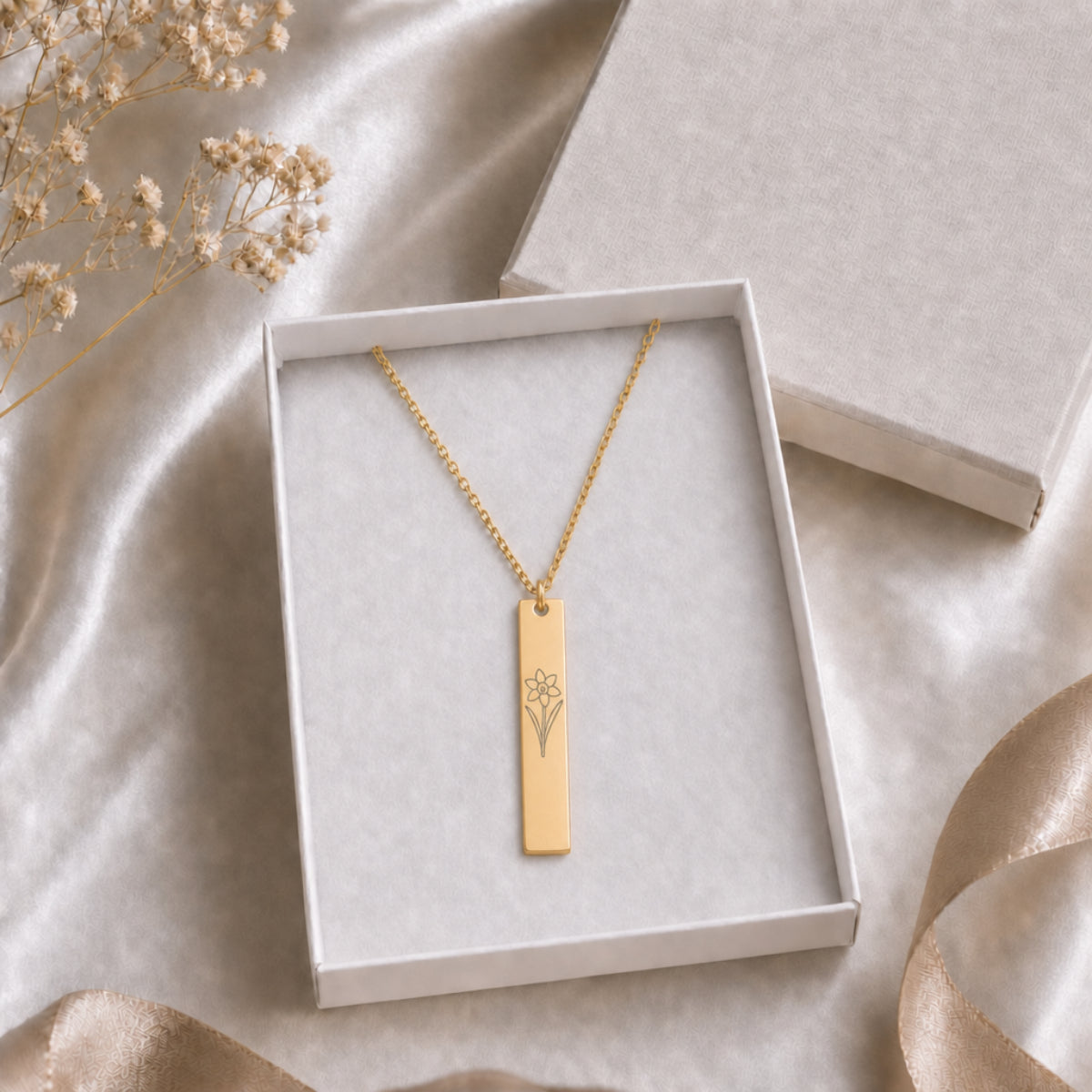 December birth flower necklace — Narcissus engraved vertical bar pendant in cream gift-ready box, premium editorial unboxing