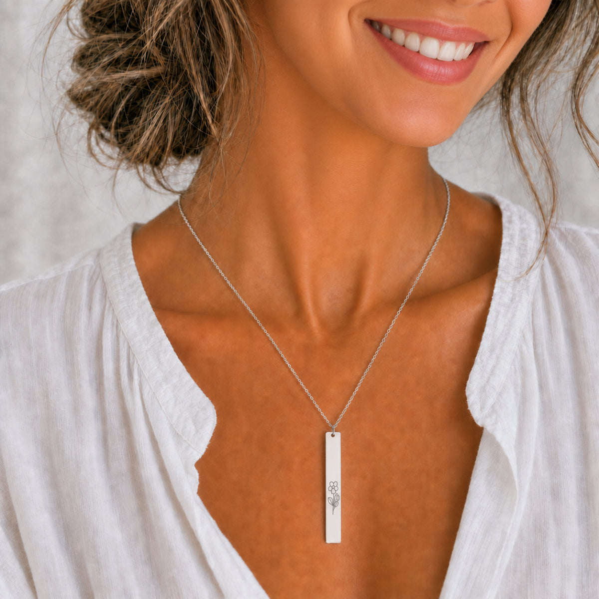 February birth flower necklace — Violet engraved on 1.26" × 0.20" vertical bar pendant, Stainless Steel finish, model wearing pendant, on-neck lifestyle, 316L premium 316L stainless
