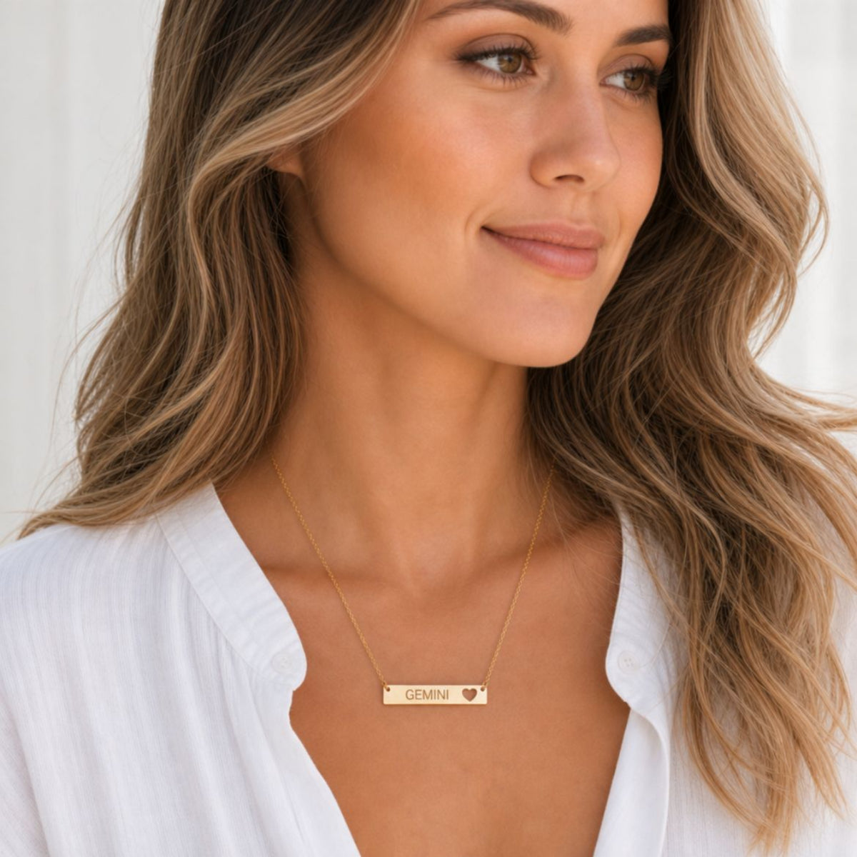 Gemini zodiac necklace — cutout heart bar pendant, 18K Gold PVD finish, model wearing pendant, on-neck lifestyle