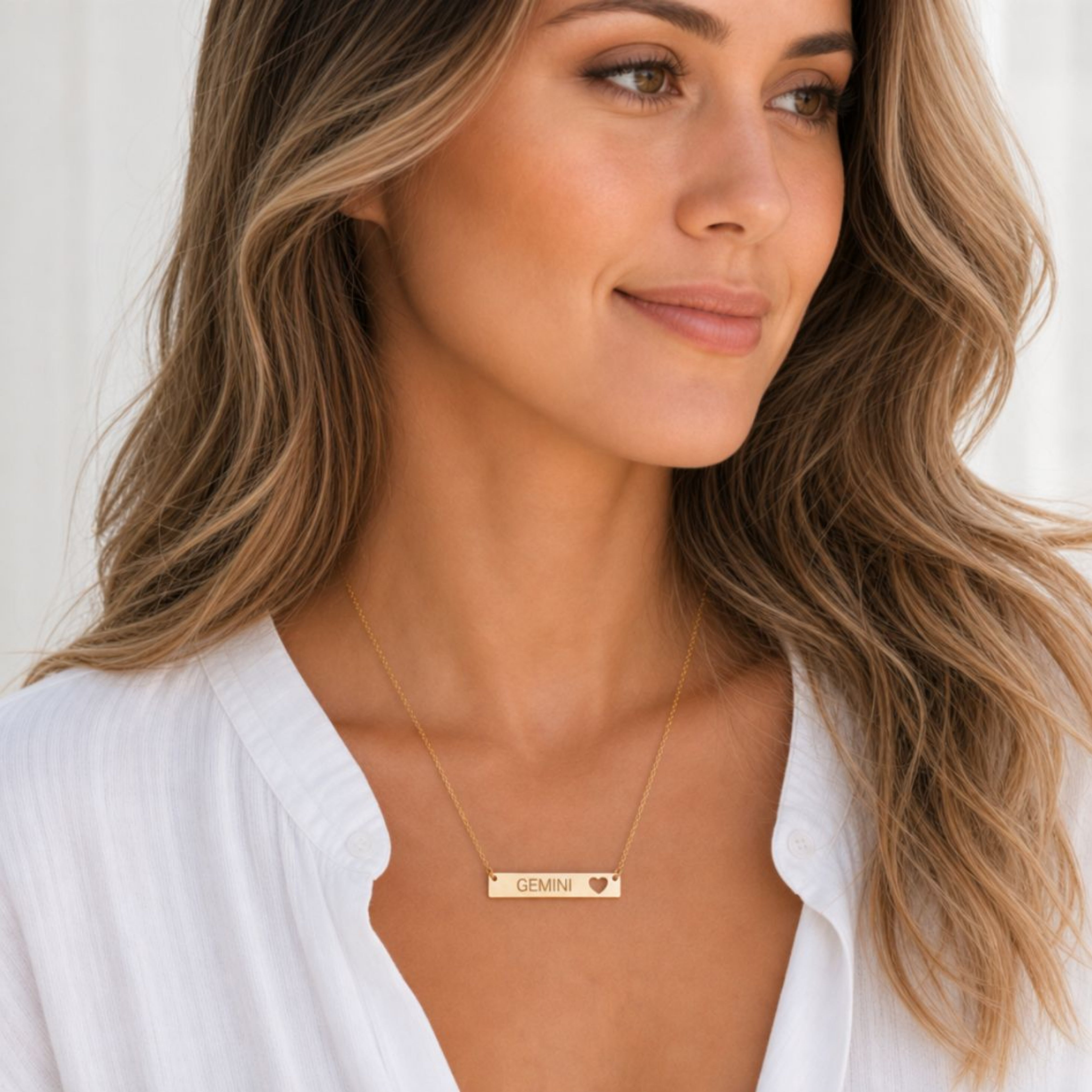 Gemini zodiac necklace — cutout heart bar pendant, 18K Gold PVD finish, model wearing pendant, on-neck lifestyle
