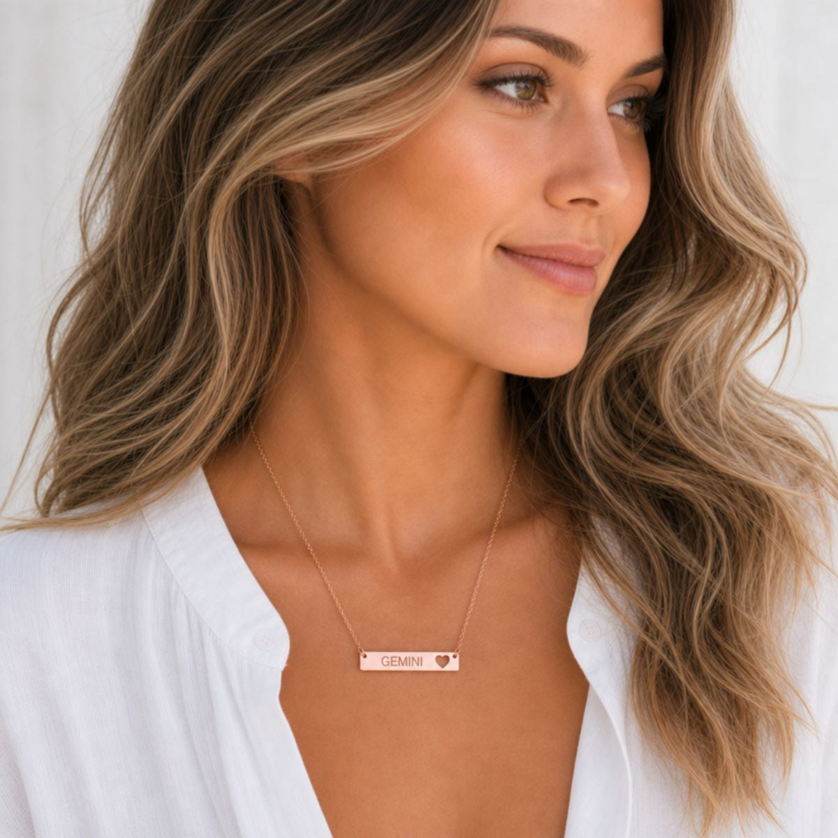 Gemini zodiac necklace — cutout heart bar pendant, 18K Rose Gold PVD finish, model wearing pendant, on-neck lifestyle