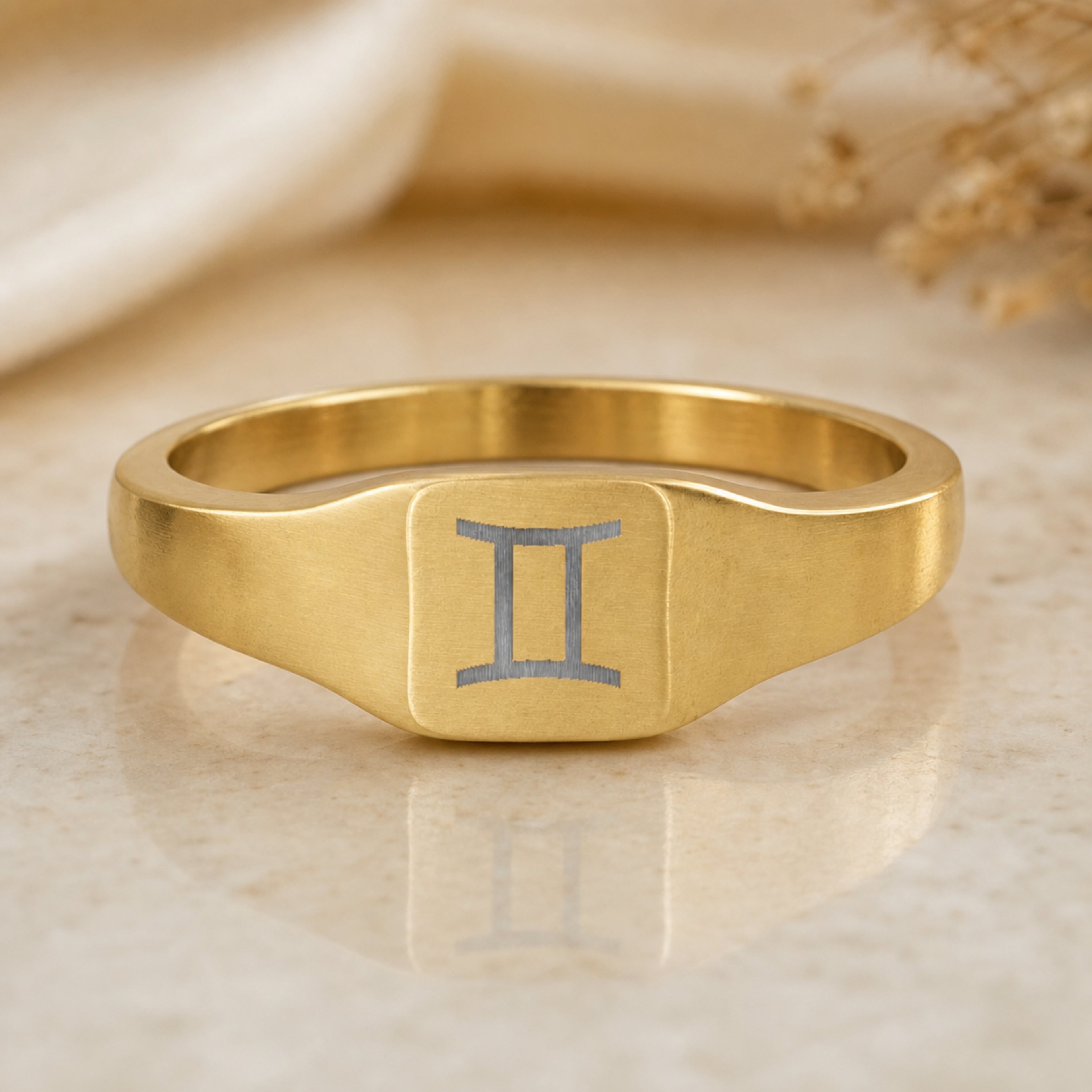 Gemini zodiac square signet ring — hero macro of laser-engraved Twins on 18K gold square face, premium personalized astrology ring gift