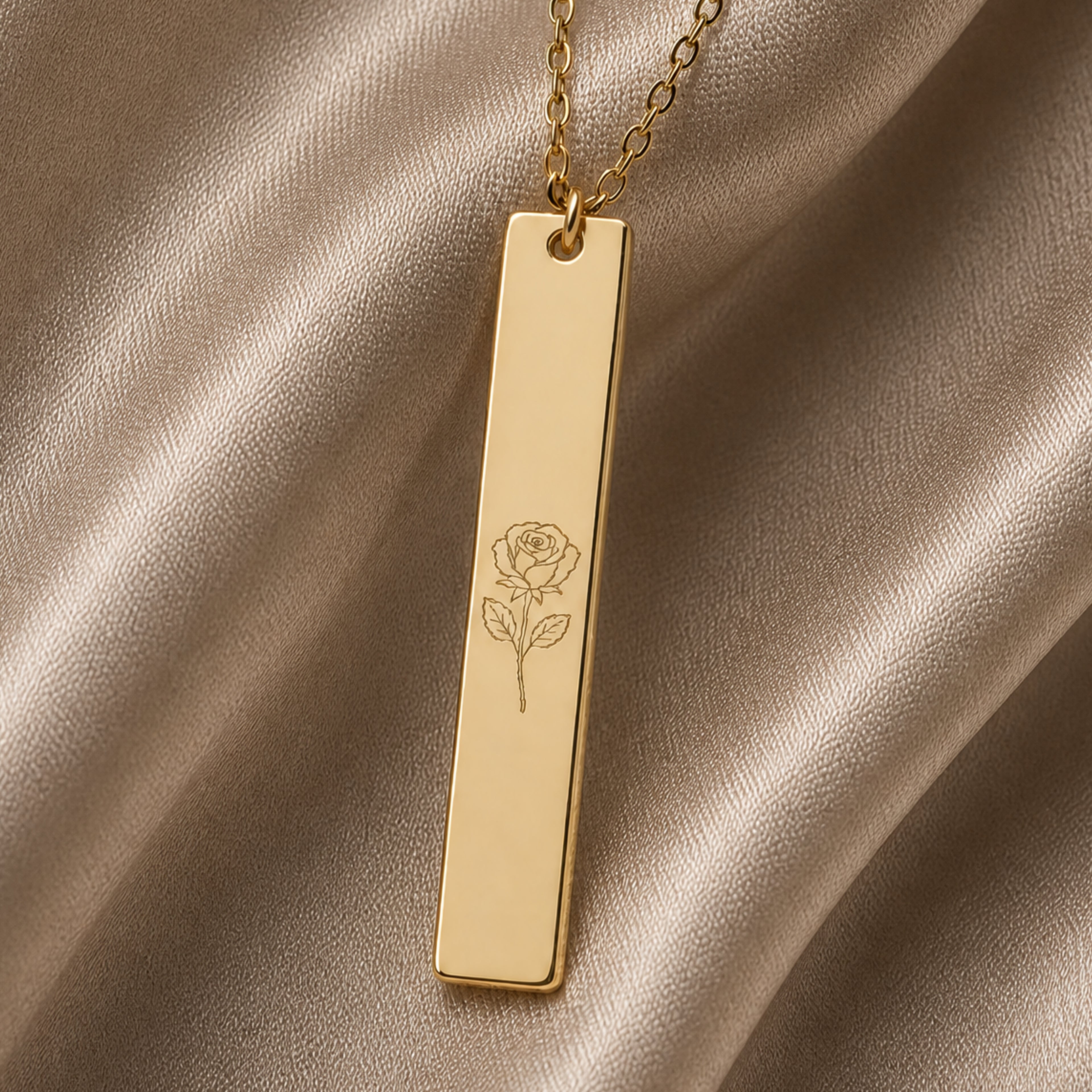 June birth flower necklace — Rose engraved vertical bar pendant flatlay with dried botanicals on cream linen