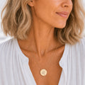 Leo zodiac coin necklace worn on model in 18K gold — engraved Leo Lion pendant resting on chest, layered everyday necklace, personalized birthday gift for Leo, July August zodiac