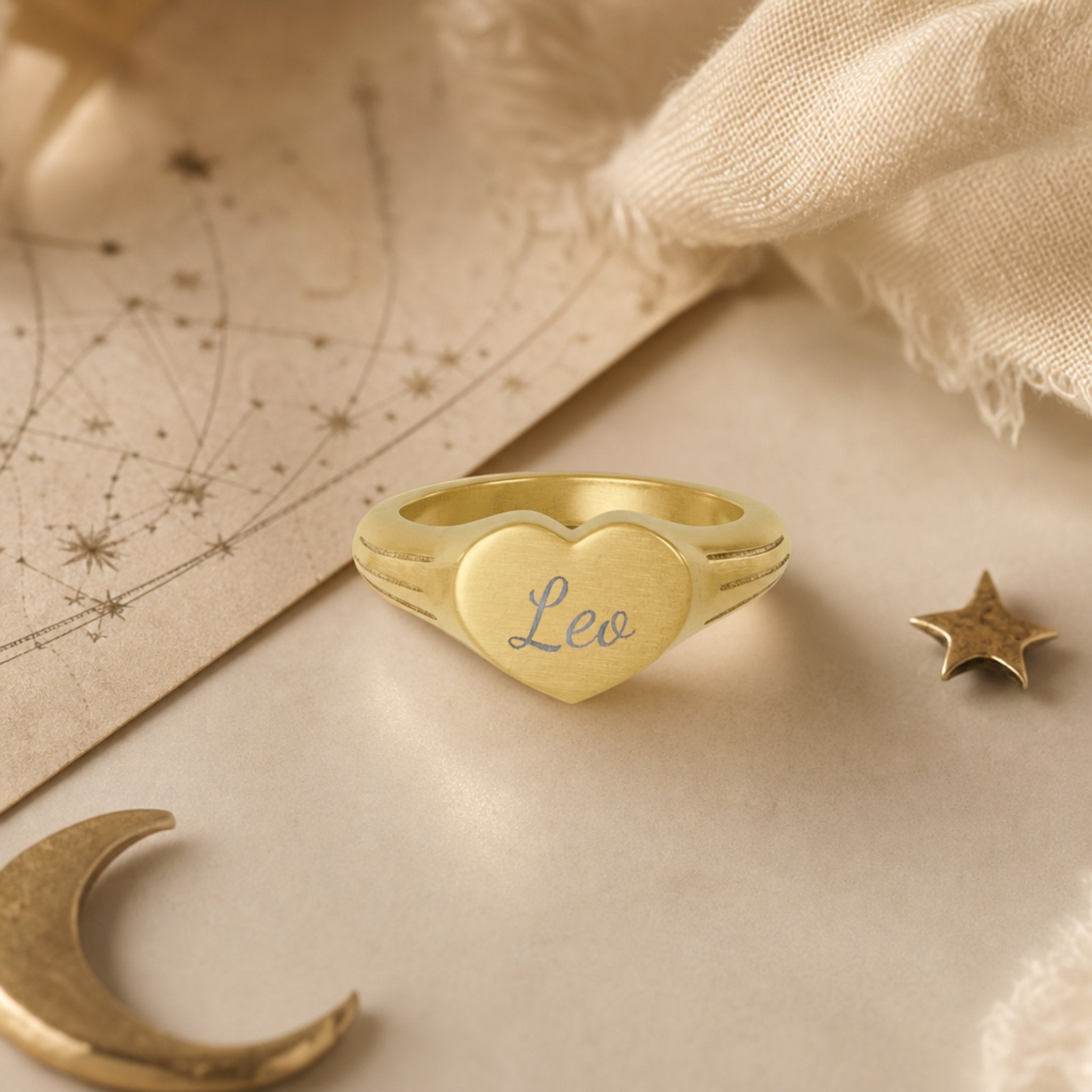 Leo zodiac heart signet ring celestial flatlay — zodiac chart and brass star with engraved Leo heart signet, astrology gift styling