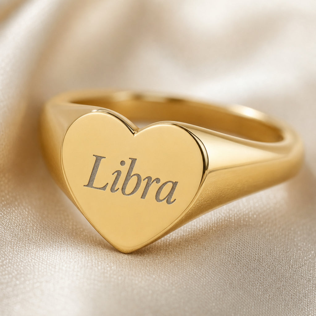 Libra zodiac heart signet ring engraving close-up — laser-etched Libra name detail, brushed grey cursive on matte gold heart
