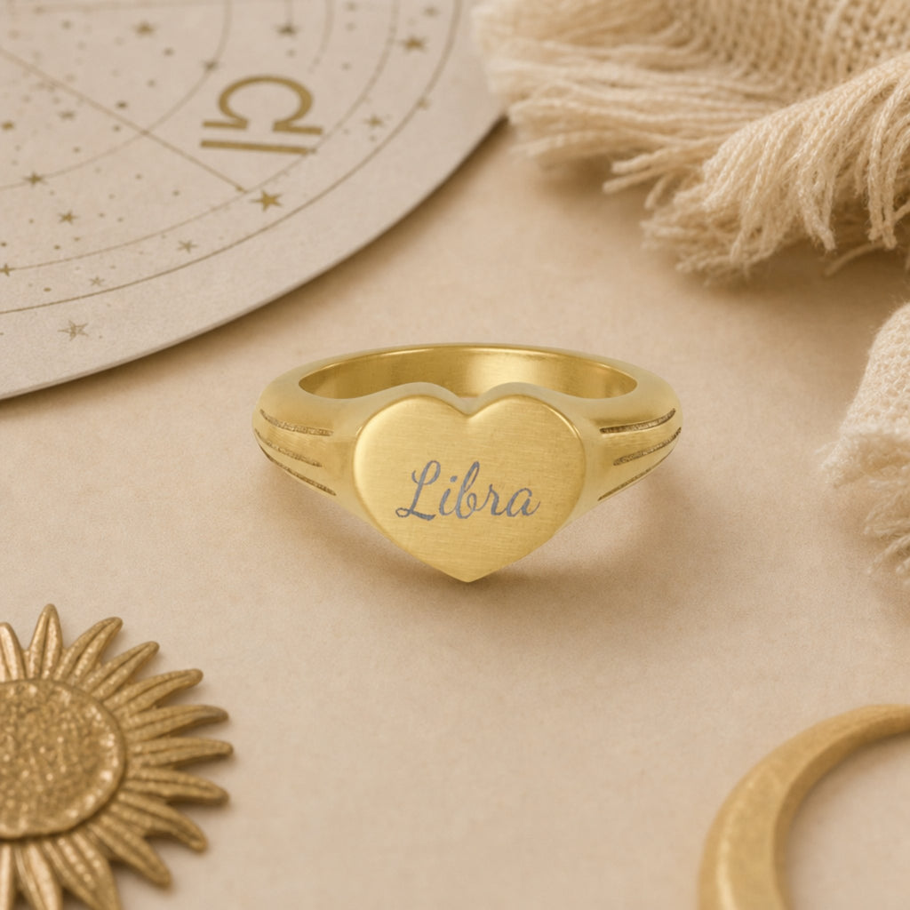 Libra zodiac heart signet ring celestial flatlay — zodiac chart and brass star with engraved Libra heart signet, astrology gift styling
