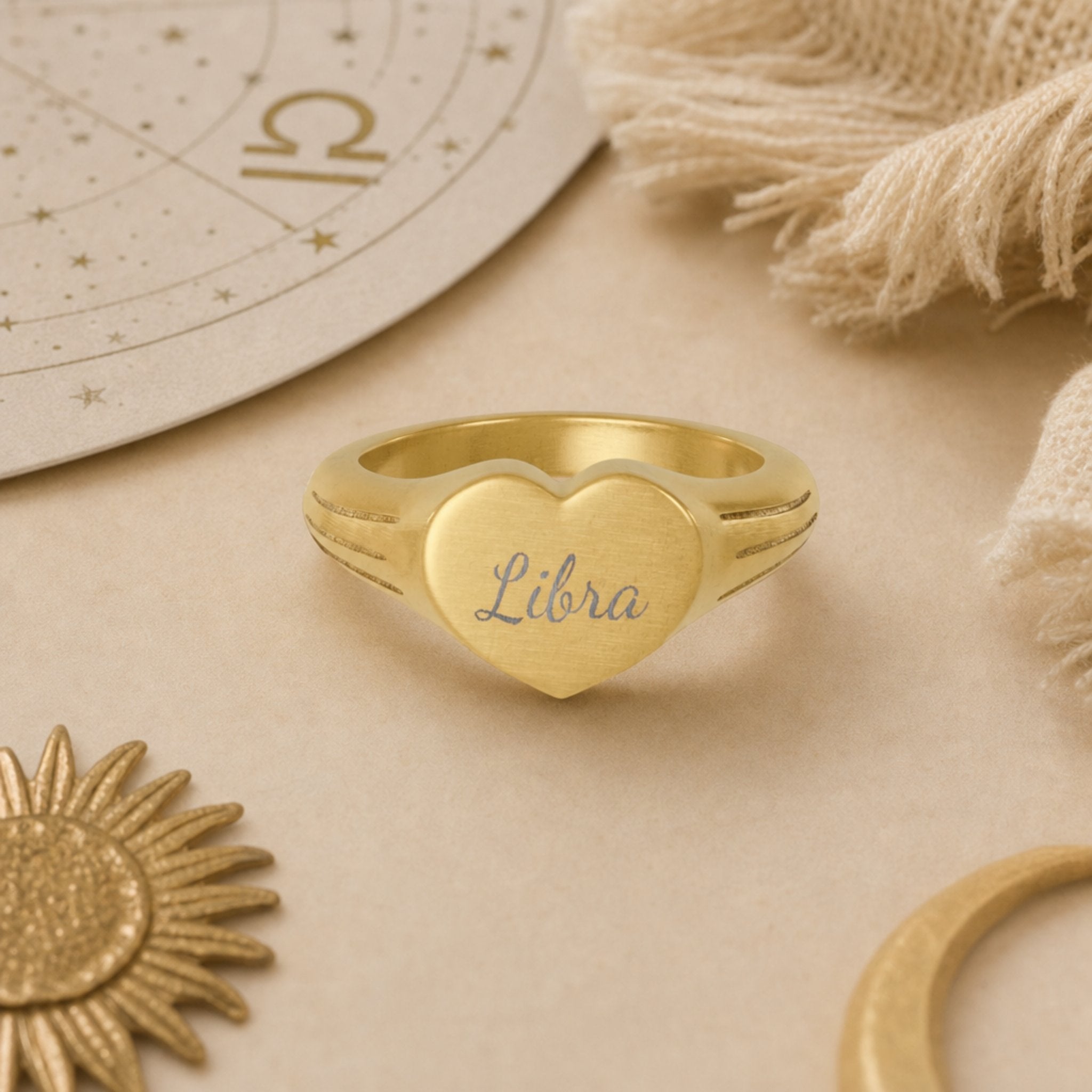 Libra zodiac heart signet ring celestial flatlay — zodiac chart and brass star with engraved Libra heart signet, astrology gift styling