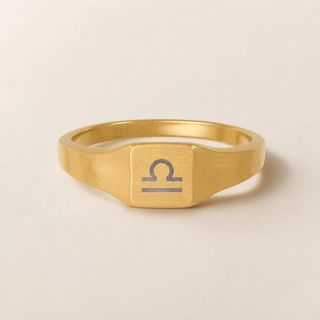 Libra zodiac square signet ring studio front — clean cream backdrop product shot, 18K gold matte PVD
