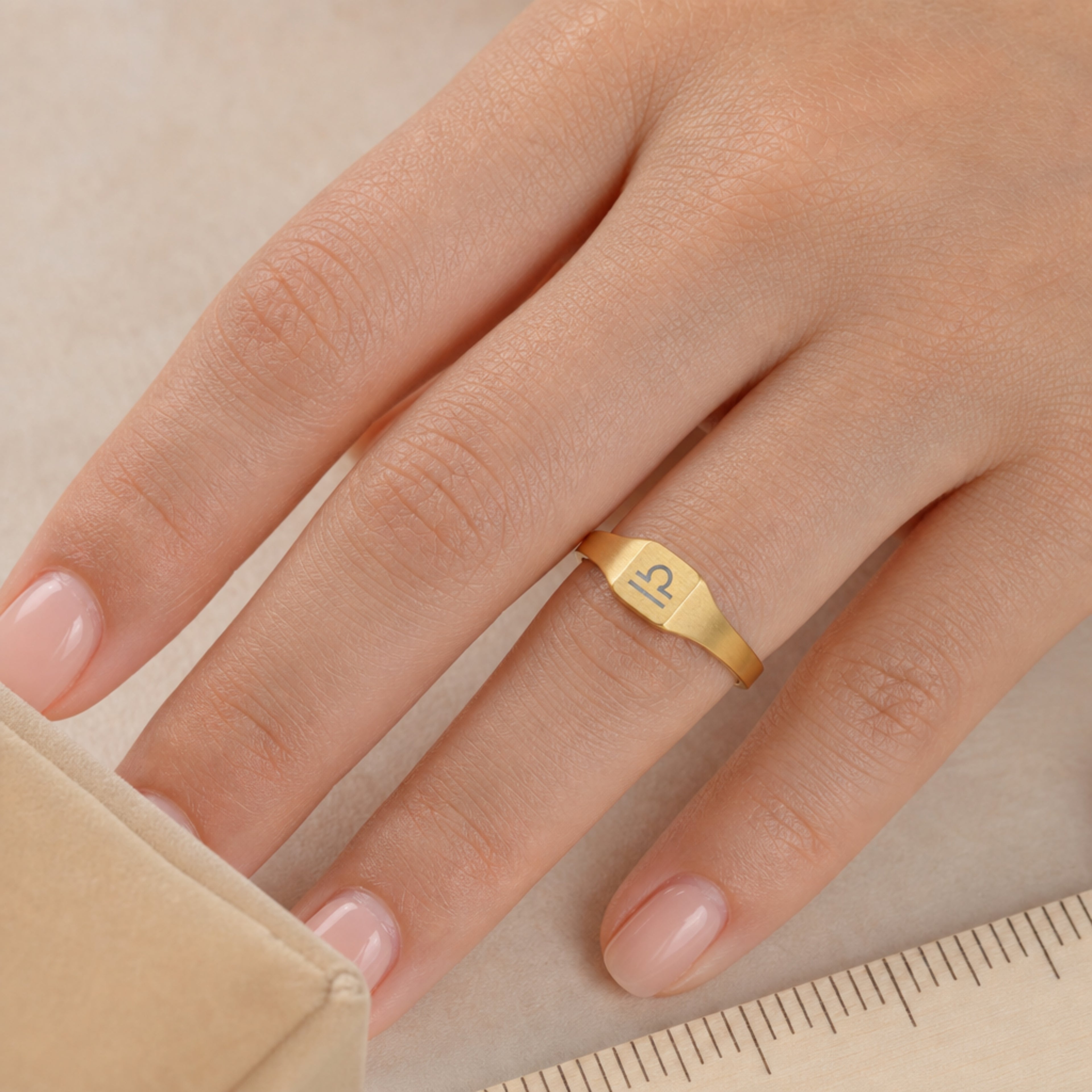 Libra zodiac square signet ring scale-in-hand — fingers holding ring next to gift box and ruler, dainty 20mm signet sizing