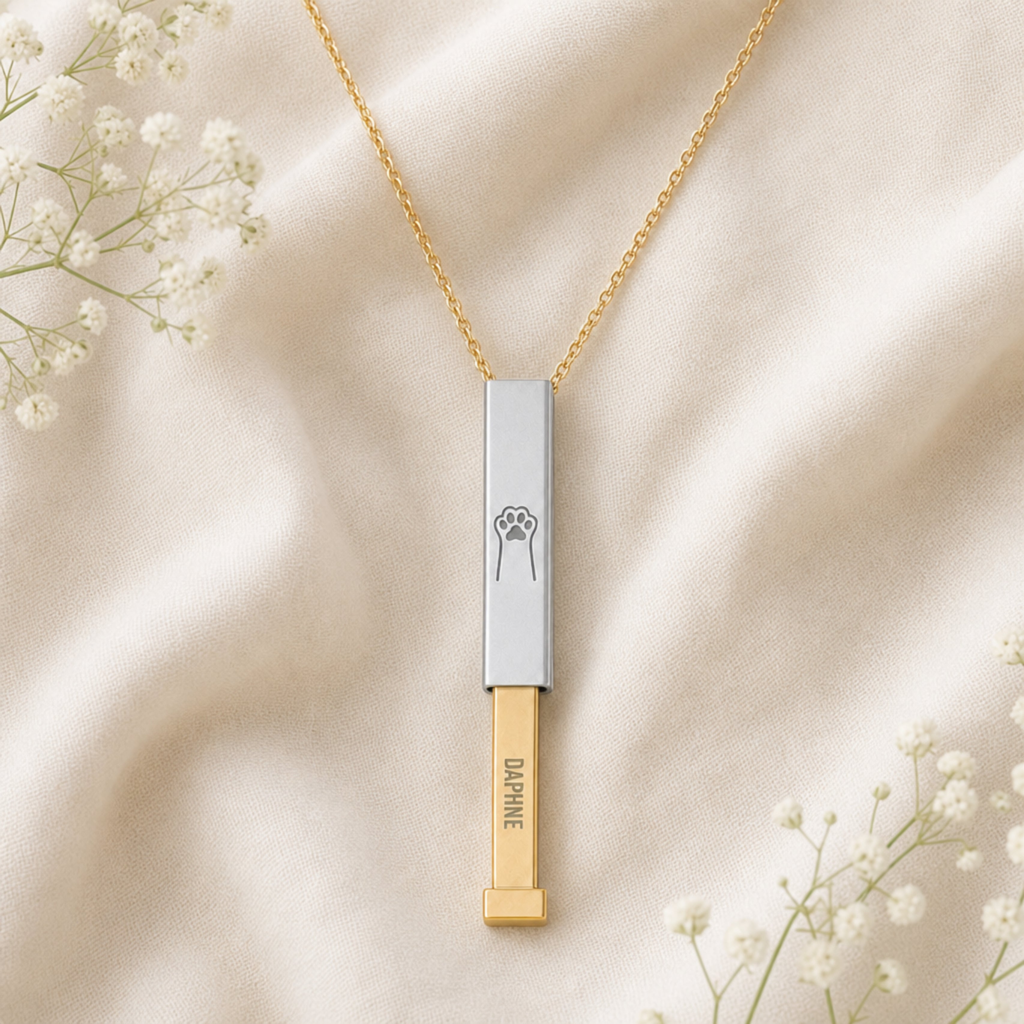 Flatlay of the personalized cat paw hidden-message sliding bar necklace