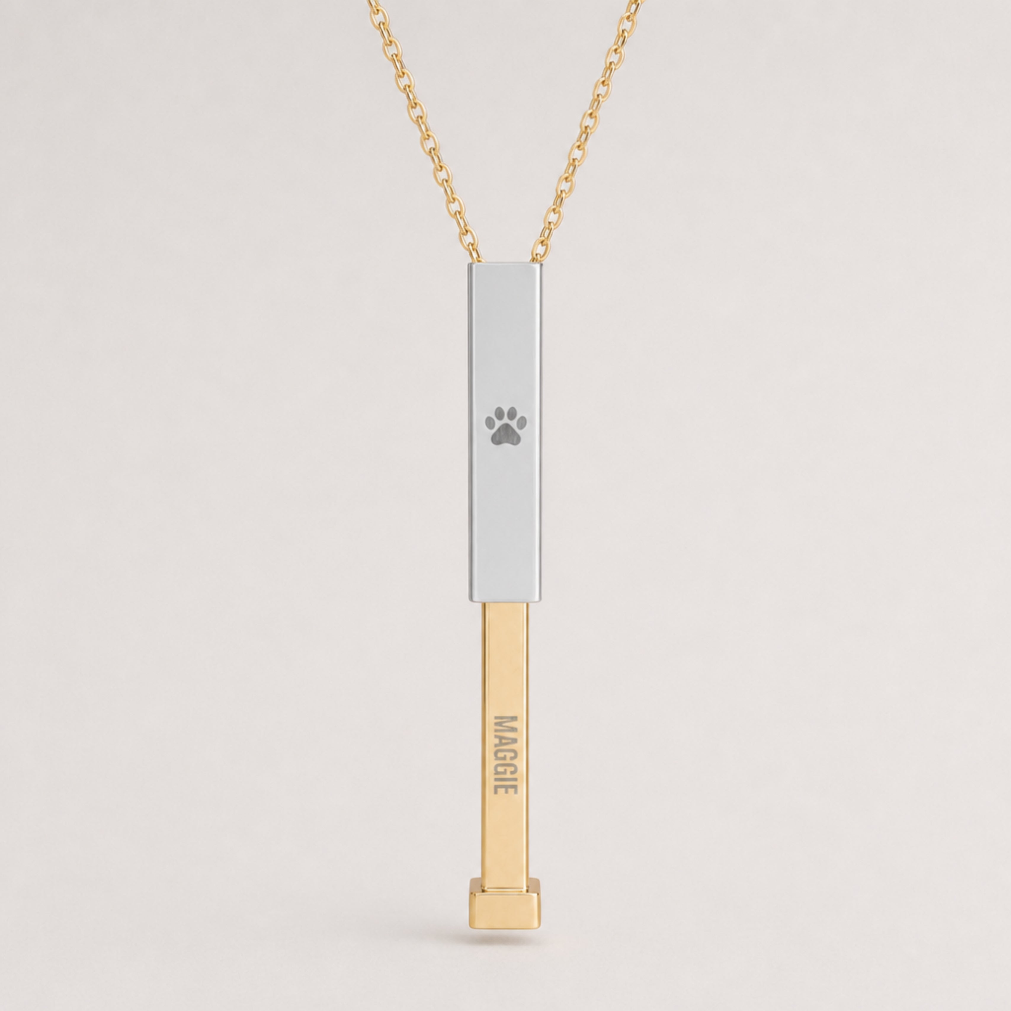 Close-up of the dog paw cutout and hidden-message sliding bar pendant, engraved name