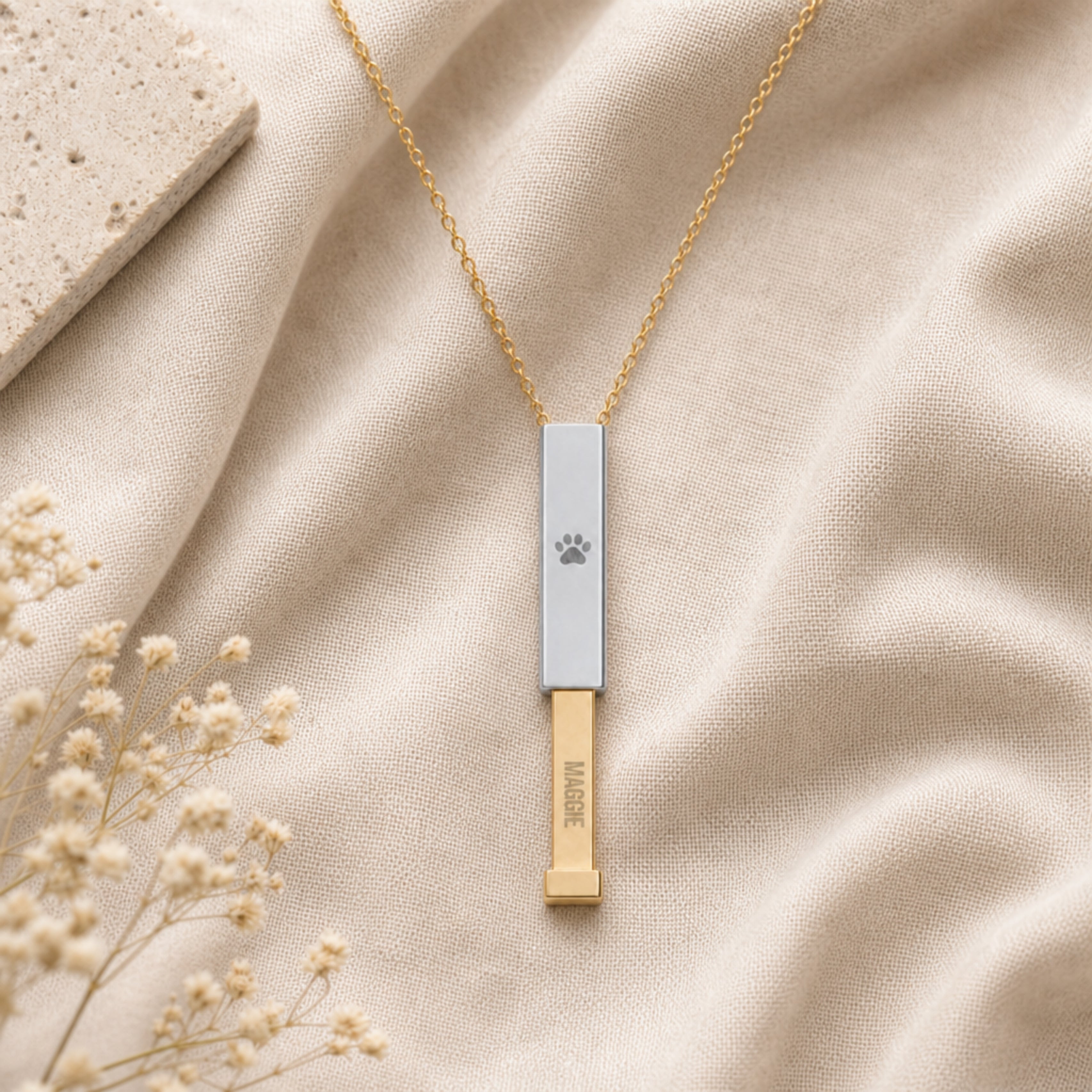 Flatlay of the personalized dog paw hidden-message sliding bar necklace