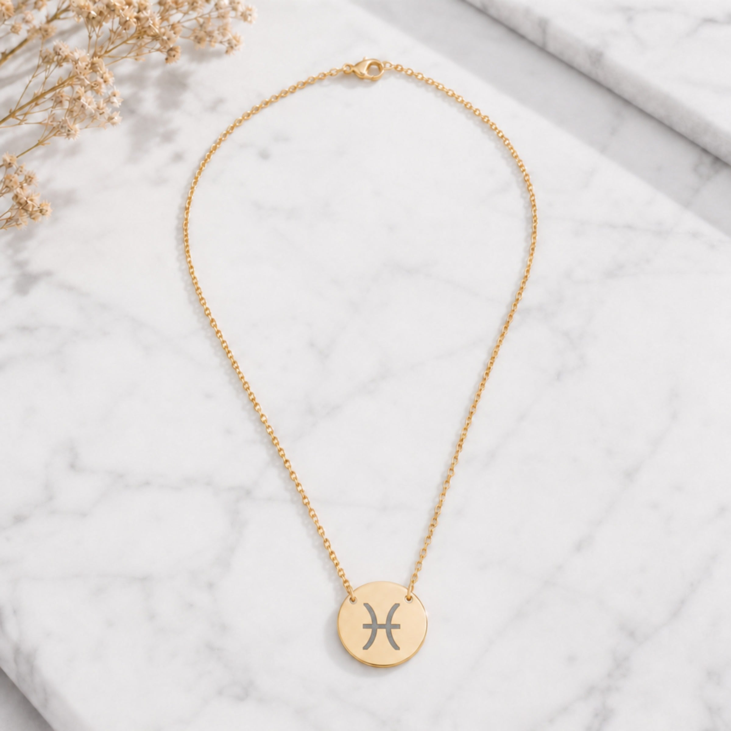 Pisces zodiac coin necklace marble flatlay — 18K gold pendant engraved with Pisces Fish star sign on white marble with dried floral, premium personalized astrology necklace gift for March birthday, Piscesian present