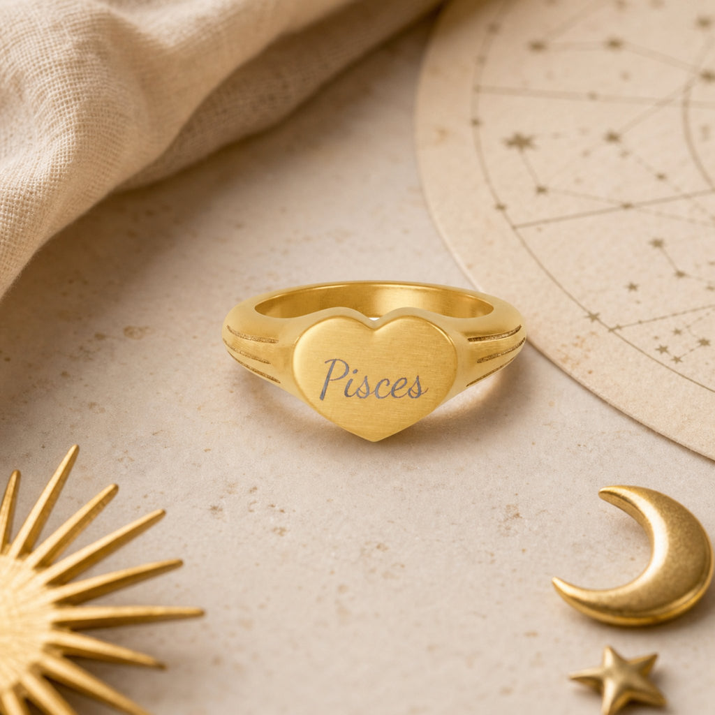 Pisces zodiac heart signet ring celestial flatlay — zodiac chart and brass star with engraved Pisces heart signet, astrology gift styling