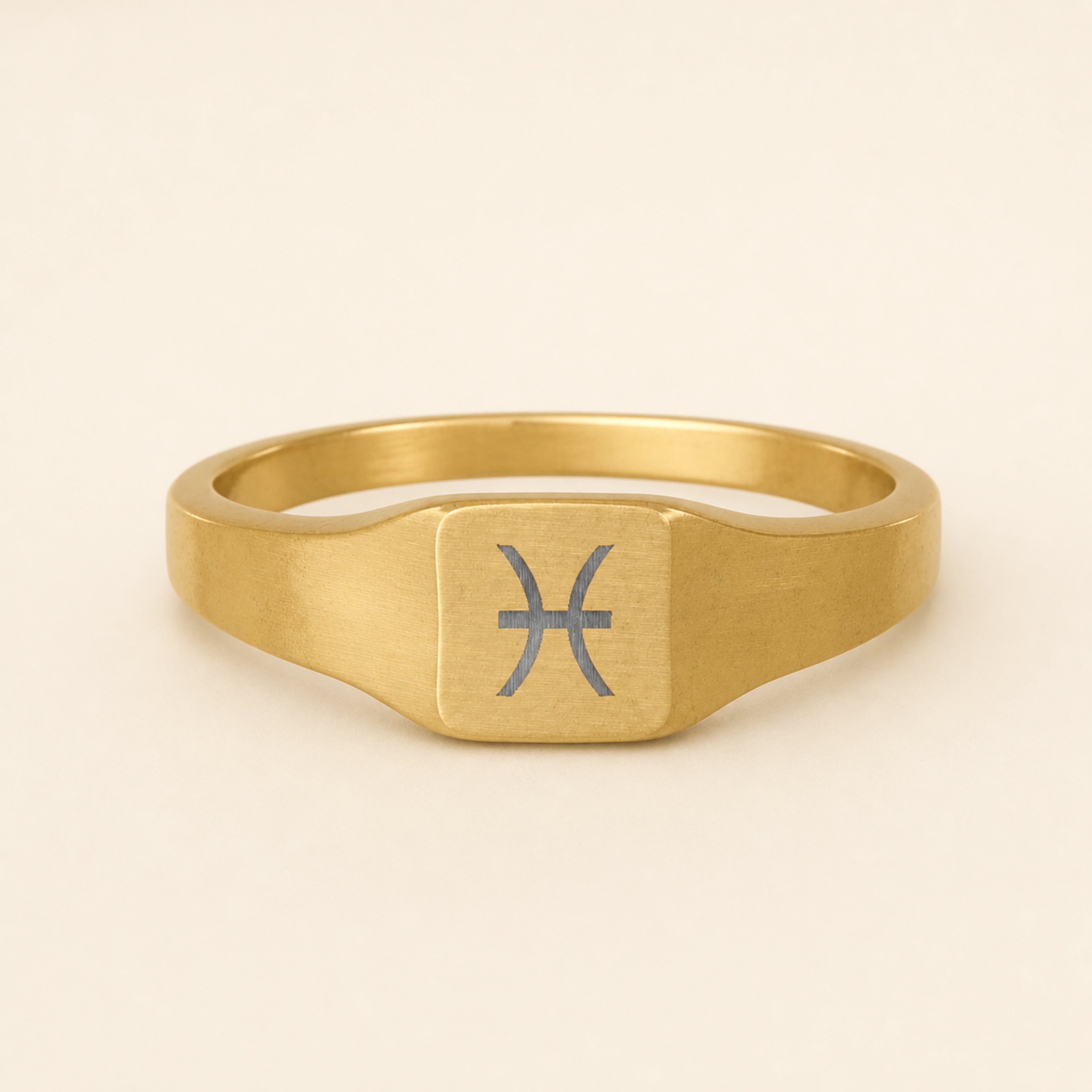 Pisces zodiac square signet ring studio front — clean cream backdrop product shot, 18K gold matte PVD