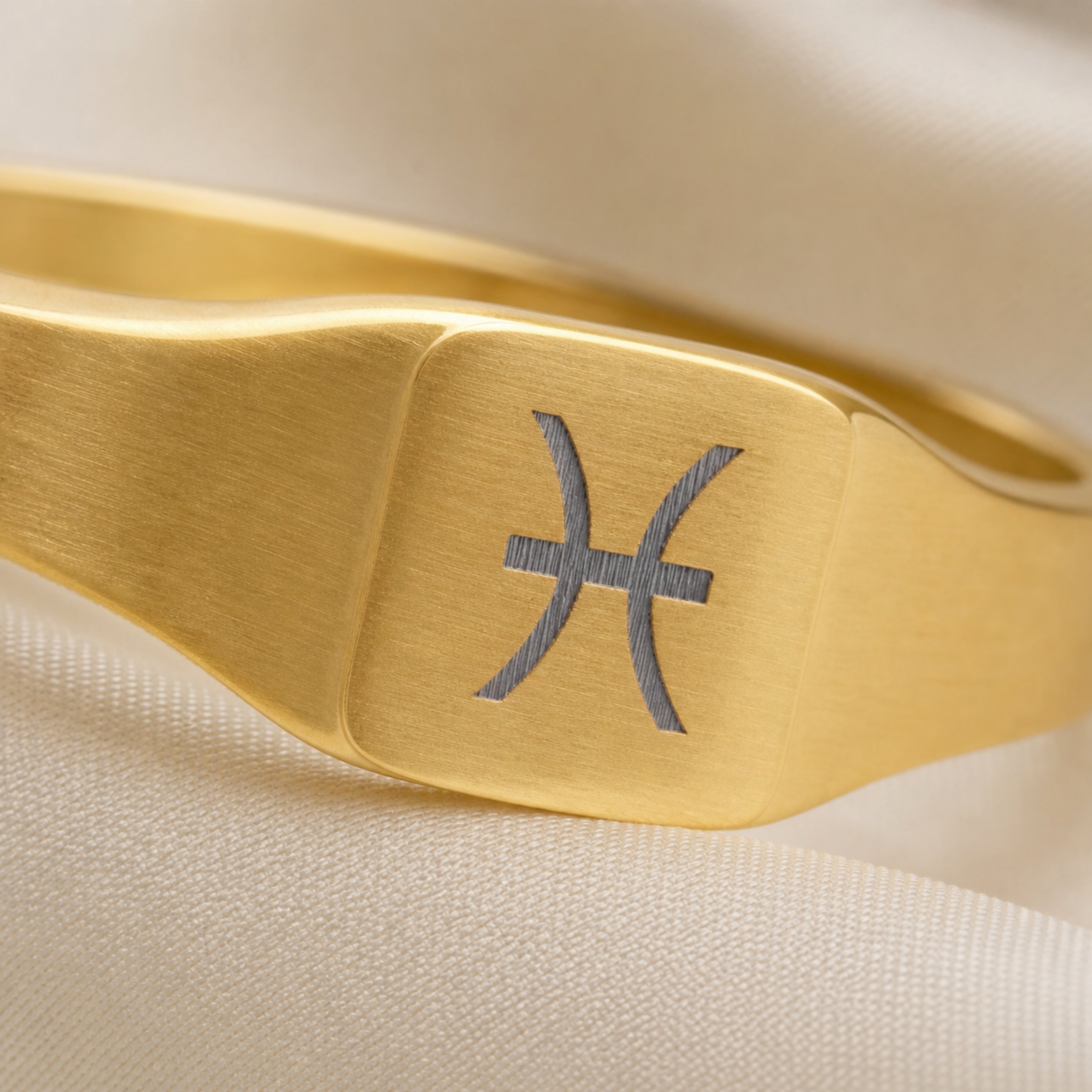 Pisces zodiac square signet ring engraving close-up — laser-etched Pisces glyph detail, brushed grey on matte gold